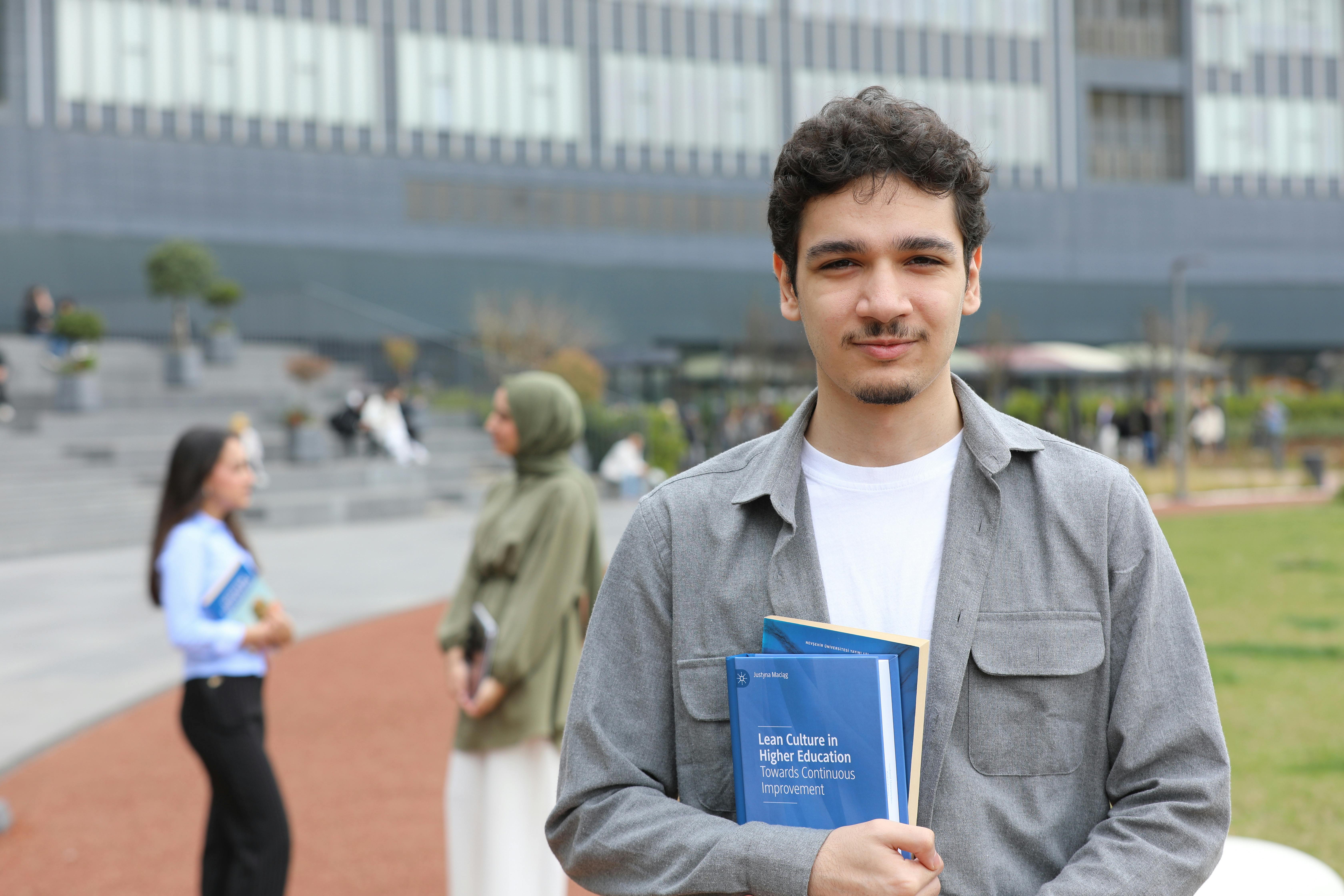 a-young-adult-student-stands-outside-on-campus-holding-textbooks,-symbolizing-ed - yusuf-çelik (pexels)