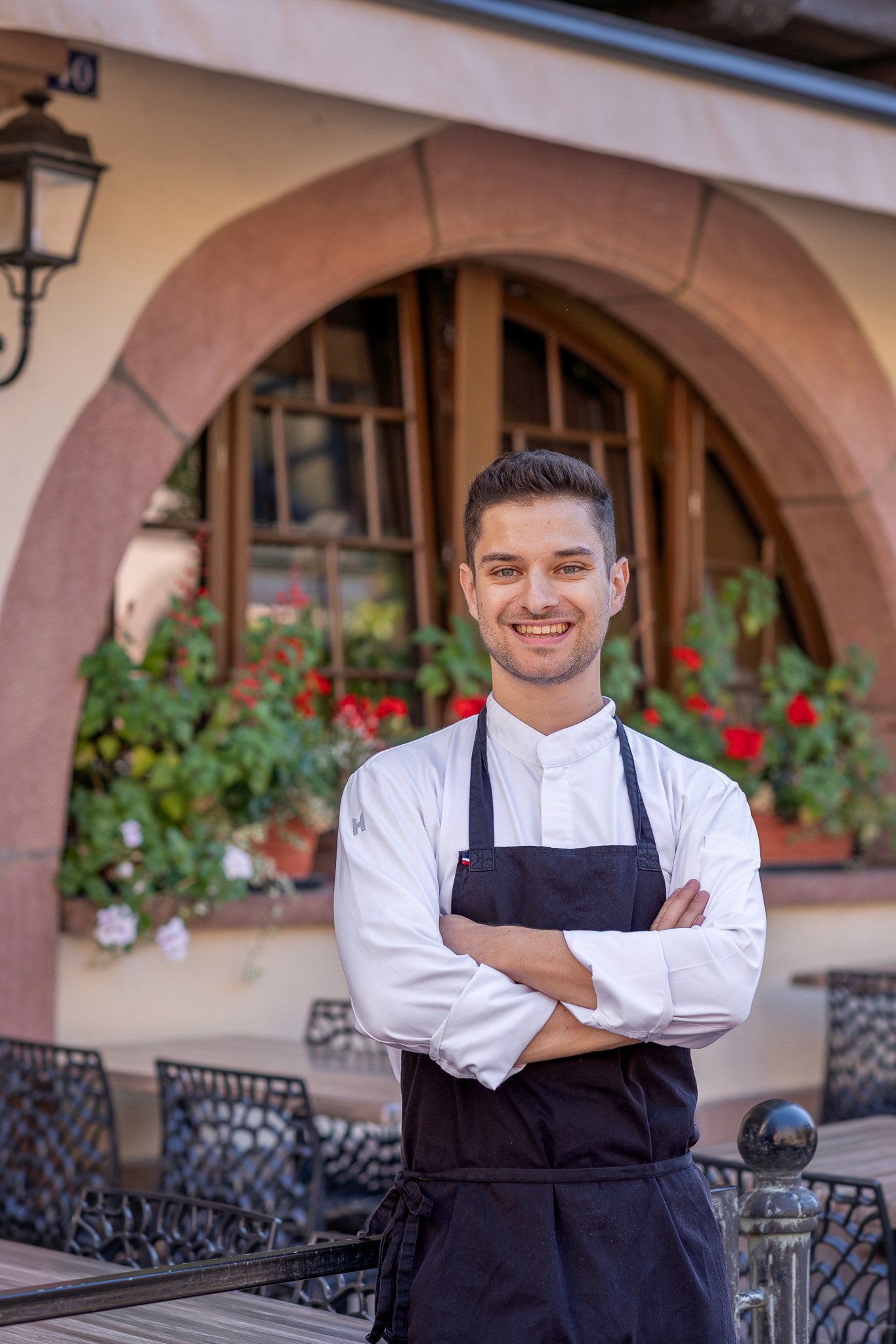 Portrait of the head chef standing at the restaurant entrance.