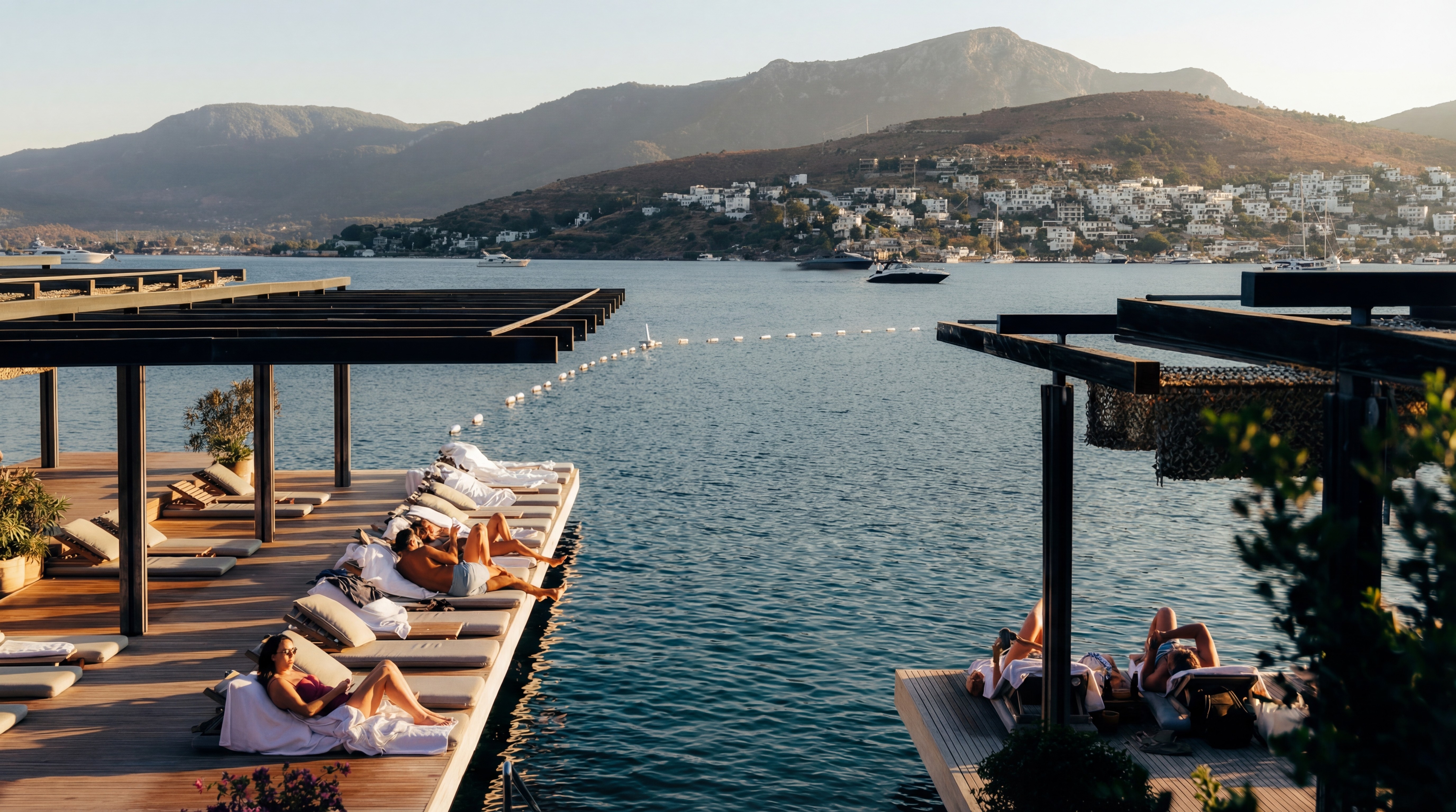 Maçakızı Beach Club Türkbükü Bodrum with wooden deck, sunbeds, and Aegean sea views