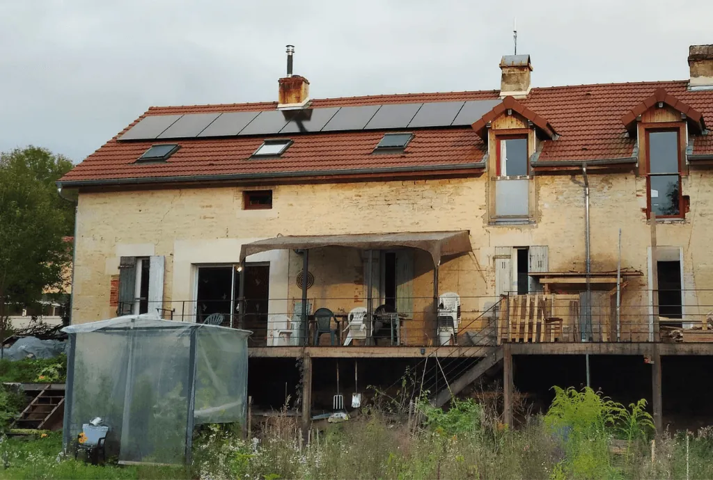 Photo d'une maison où on voit que le toit est équipé d'une installation de panneaux solaires