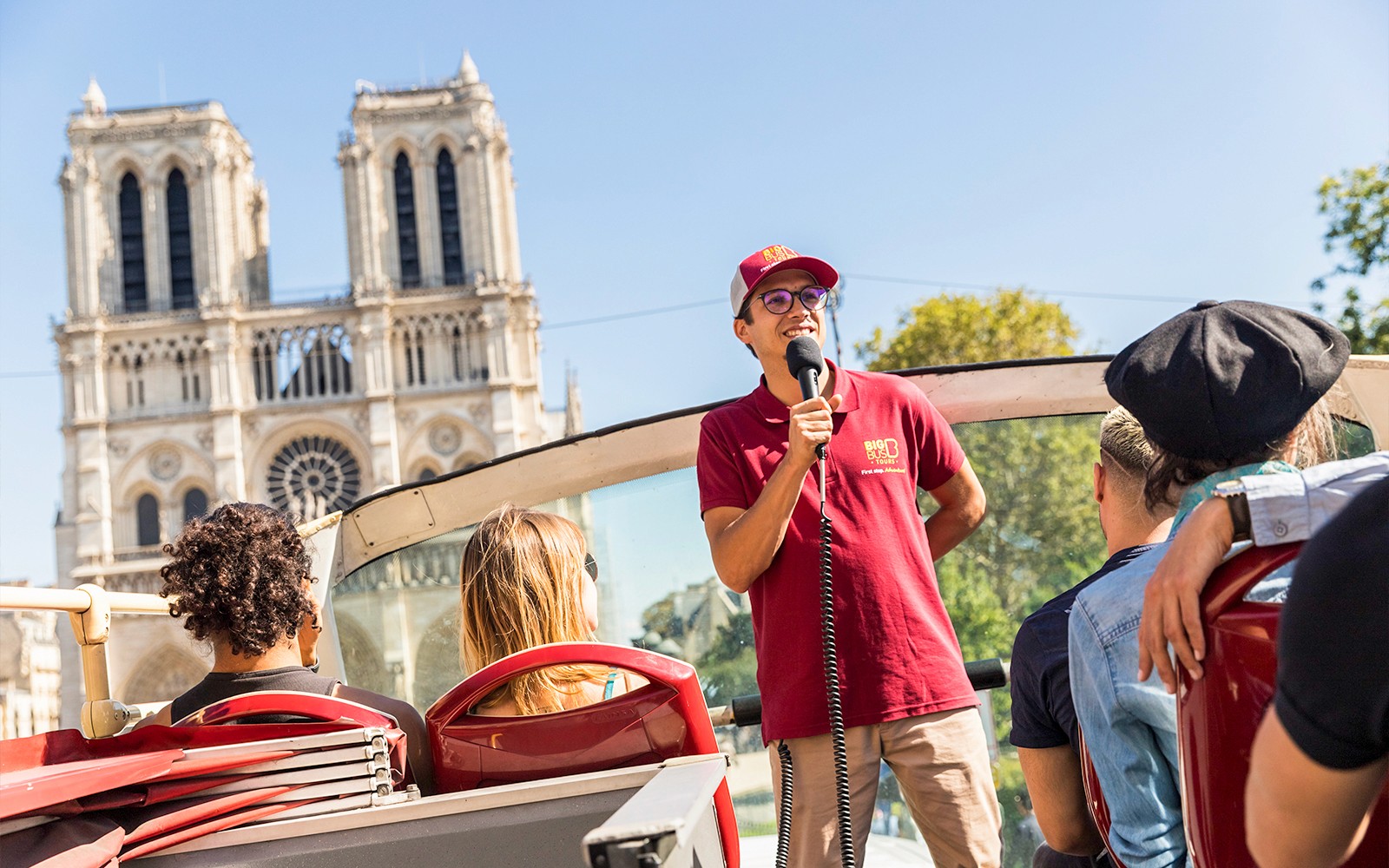 Guía turístico hablando en el Big Bus cerca de la Catedral de Notre-Dame, París.