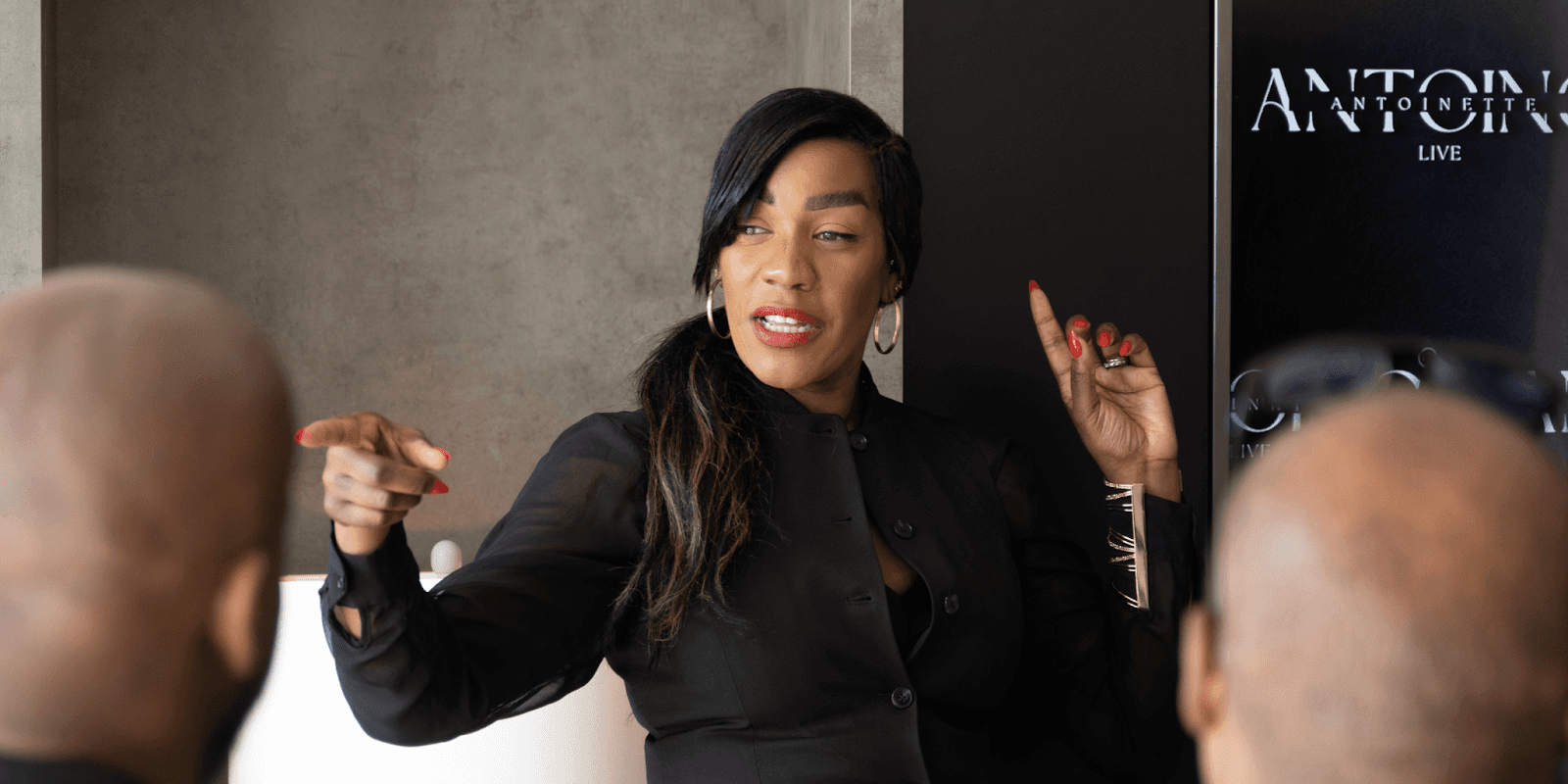 "Antoinette Antoine, executive reinvention coach, speaking passionately to a group, offering strategic guidance through leadership challenges and personal transformation."