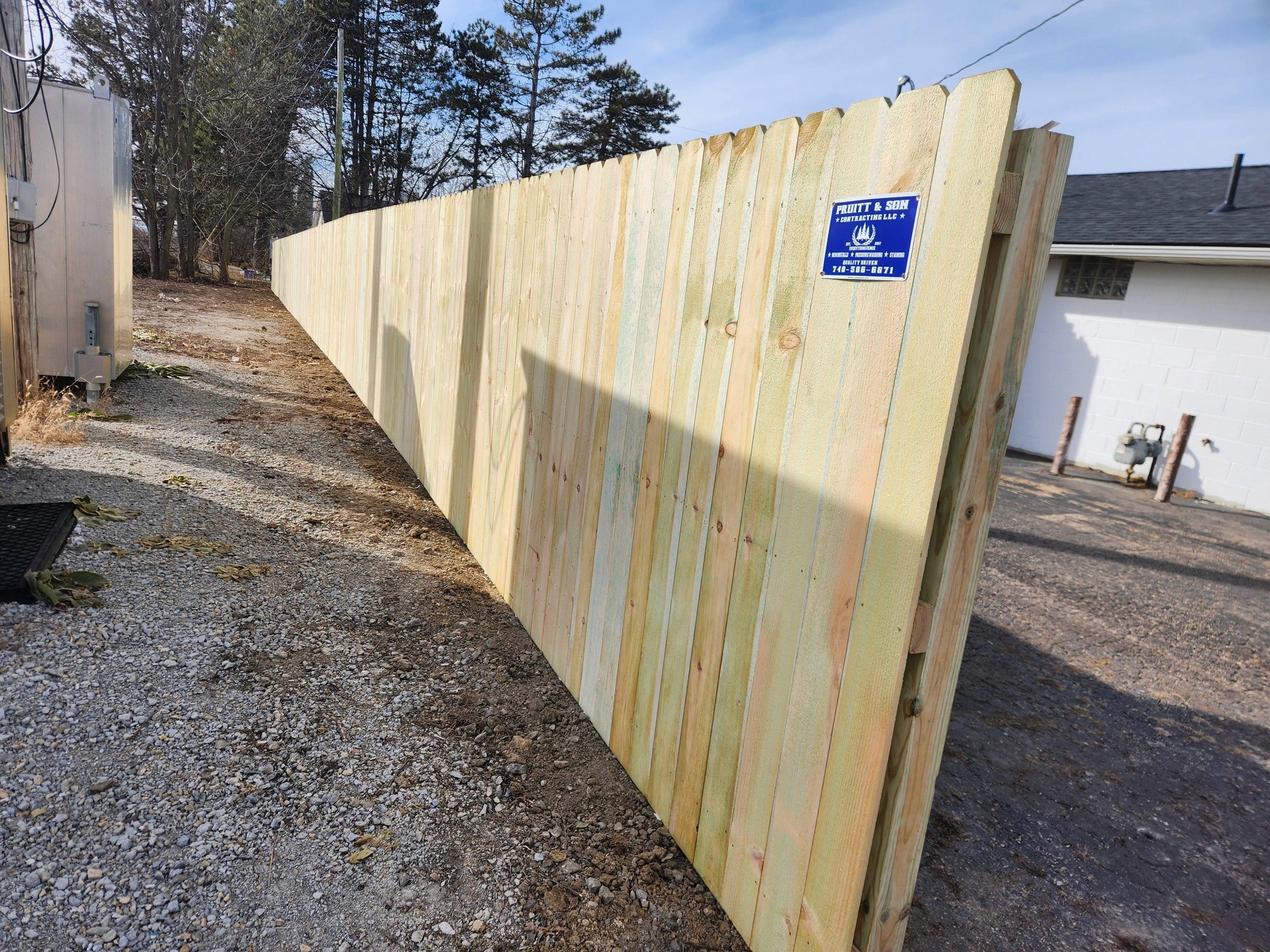Modern living room with abstract art, beige sectional sofa, indoor plants, and large windows.