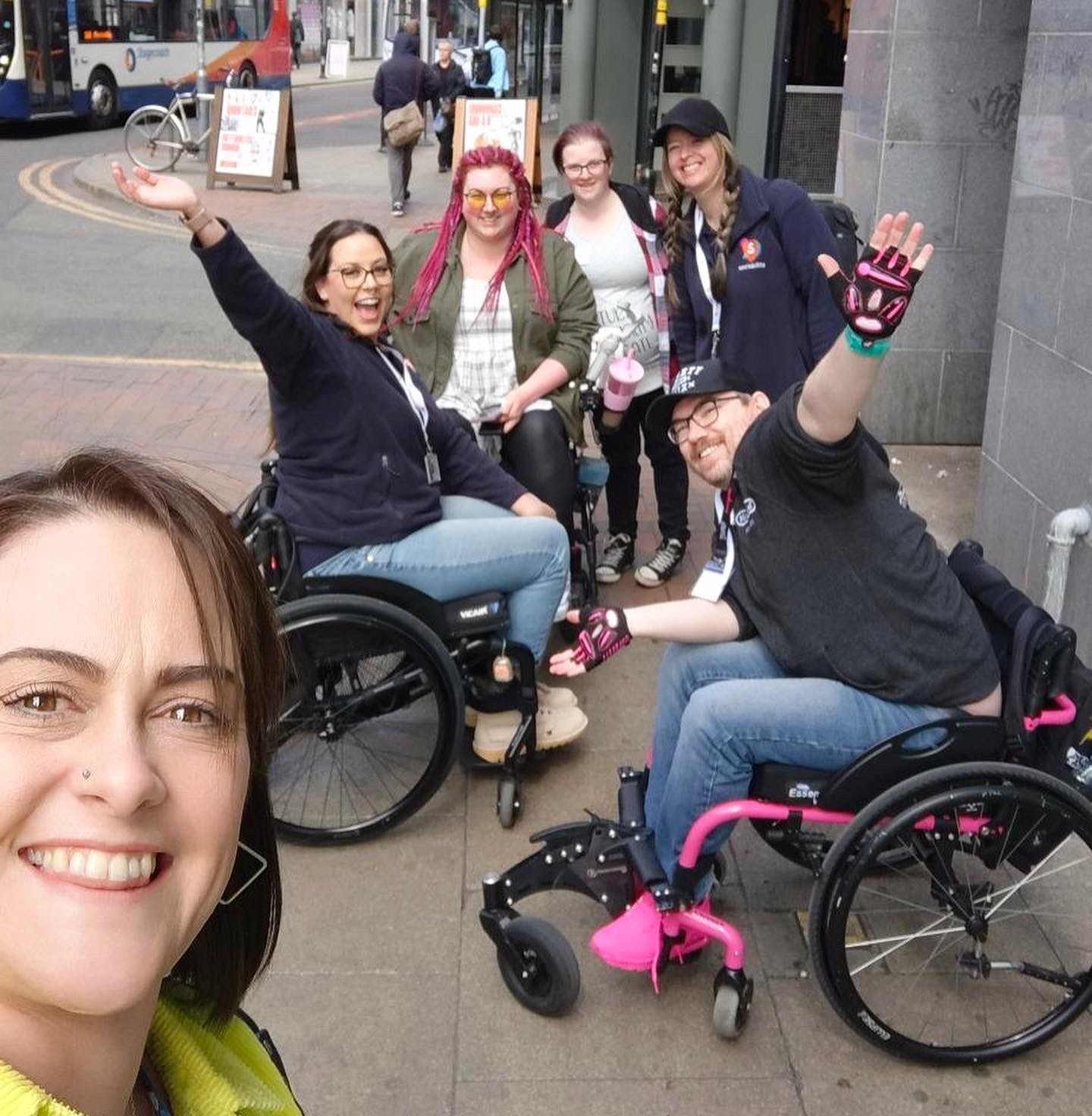 Three members of the Sociability team, one wheelchair user and two non-disabled people laughing together while completing a brainstorming activity.