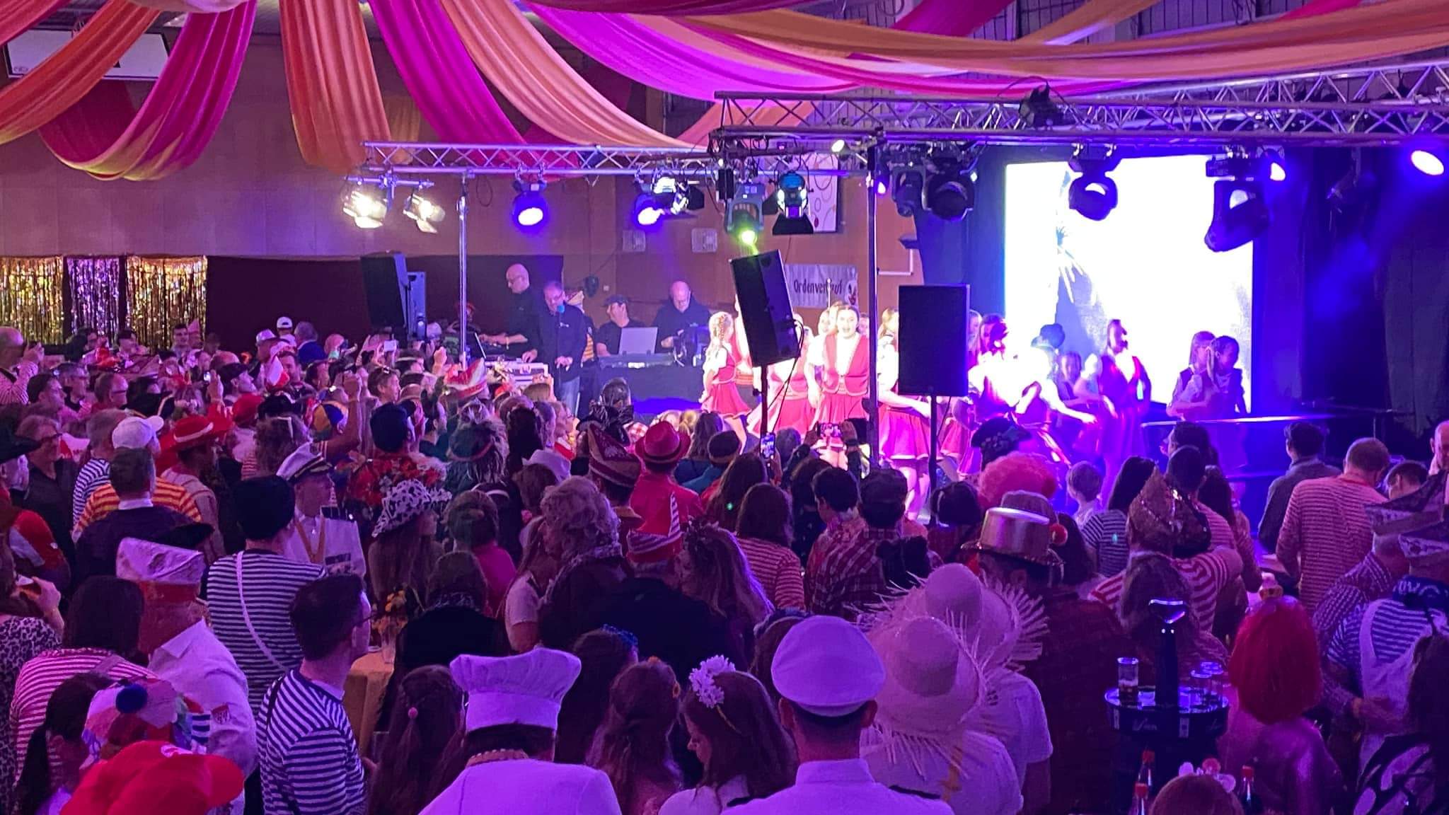 Event in großer Halle mit super Stimmung, tanzenden Menschen und professioneller Licht- und Tontechnik. 