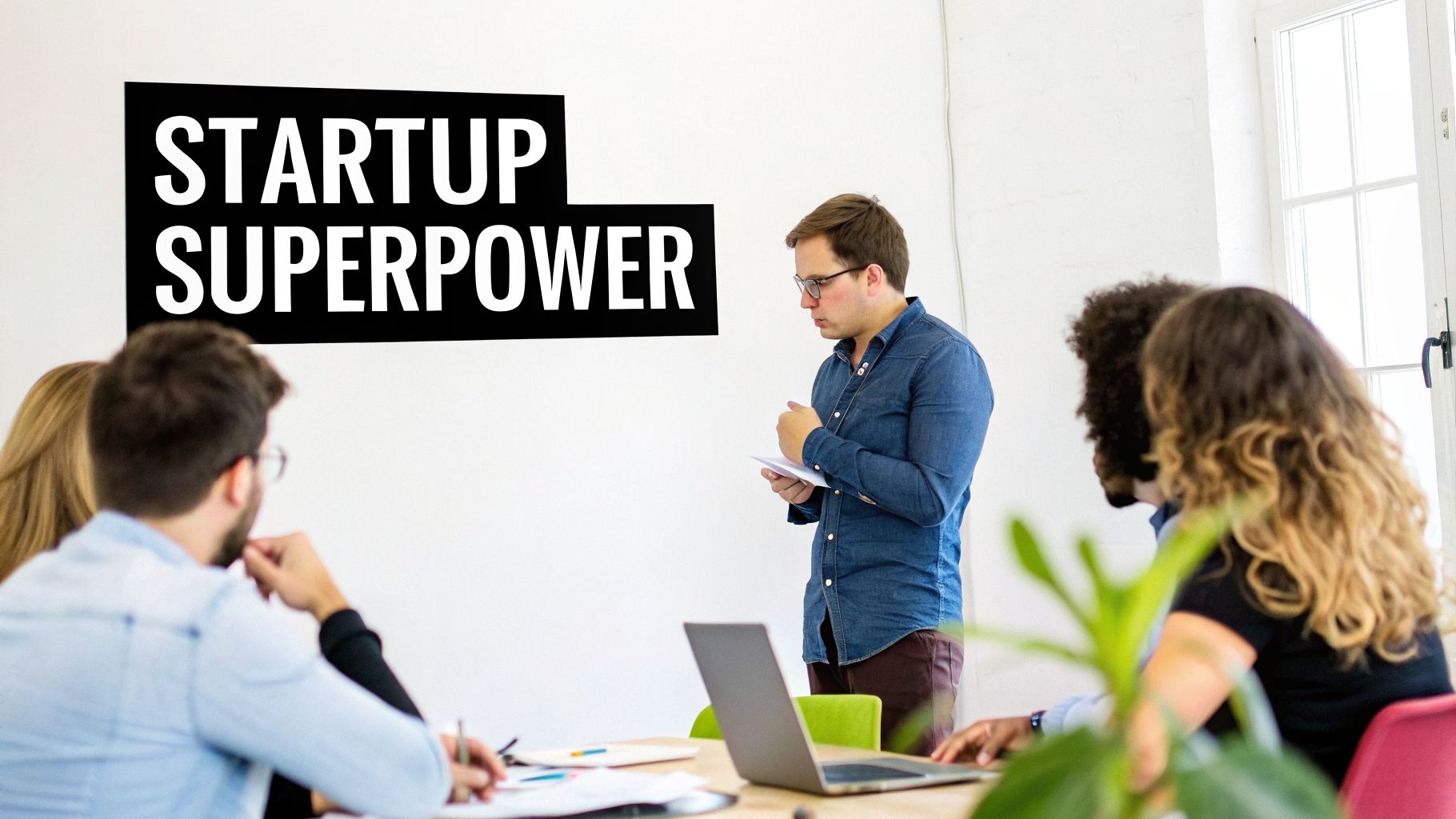 A group of professionals in a bright meeting room, one man presents while others listen, with 