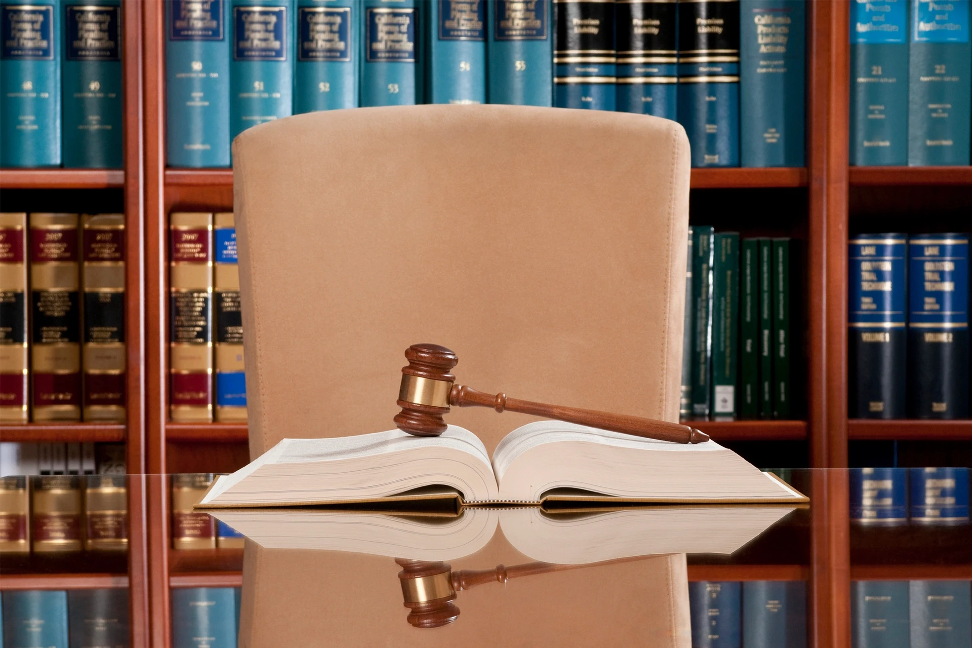Attorney’s office desk with gavel on an open law book and an empty chair, symbolizing legal support for sexual harassment case