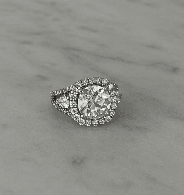 Vintage-style diamond ring photographed on a neutral background, highlighting the charm of old mine-cut diamonds