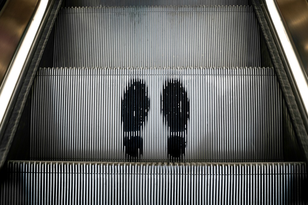 a couple of people riding down an escalator