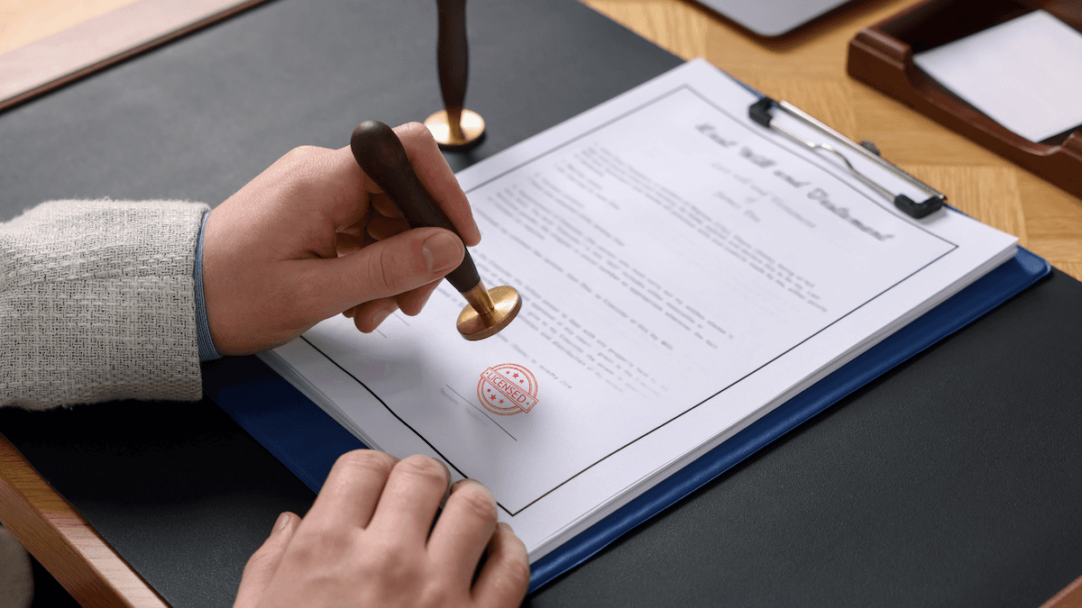 Hands using a stamp to validate official logistics contracts and documentation.