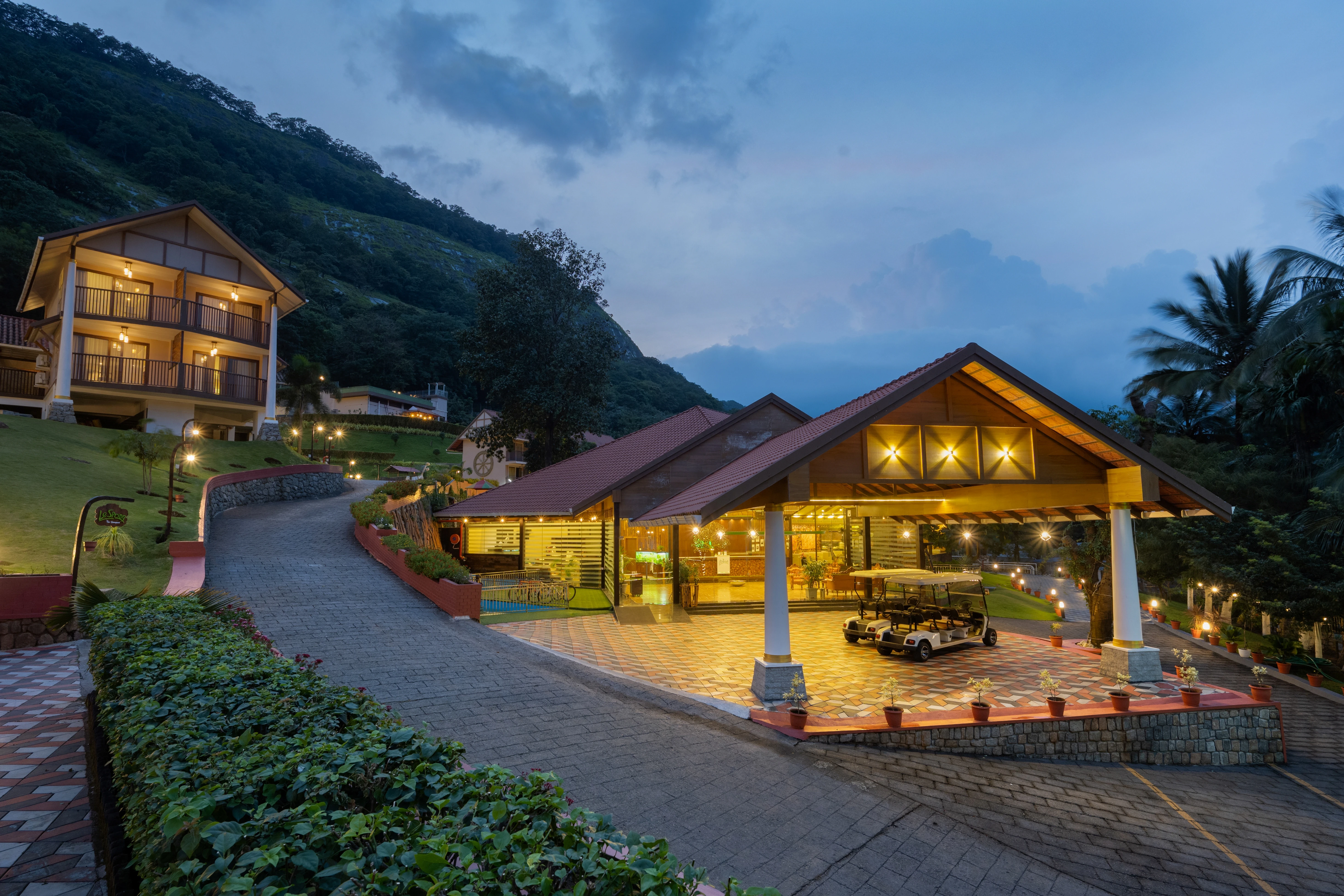 Belvoir fine dine restaurant exterior evening view in Palakkad with scenic hillside landscape, warm lights, and luxury ambience
