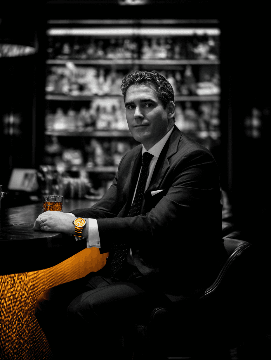 Elegantly dressed man at the Verve Club bar, gold watch, dark venue behind him