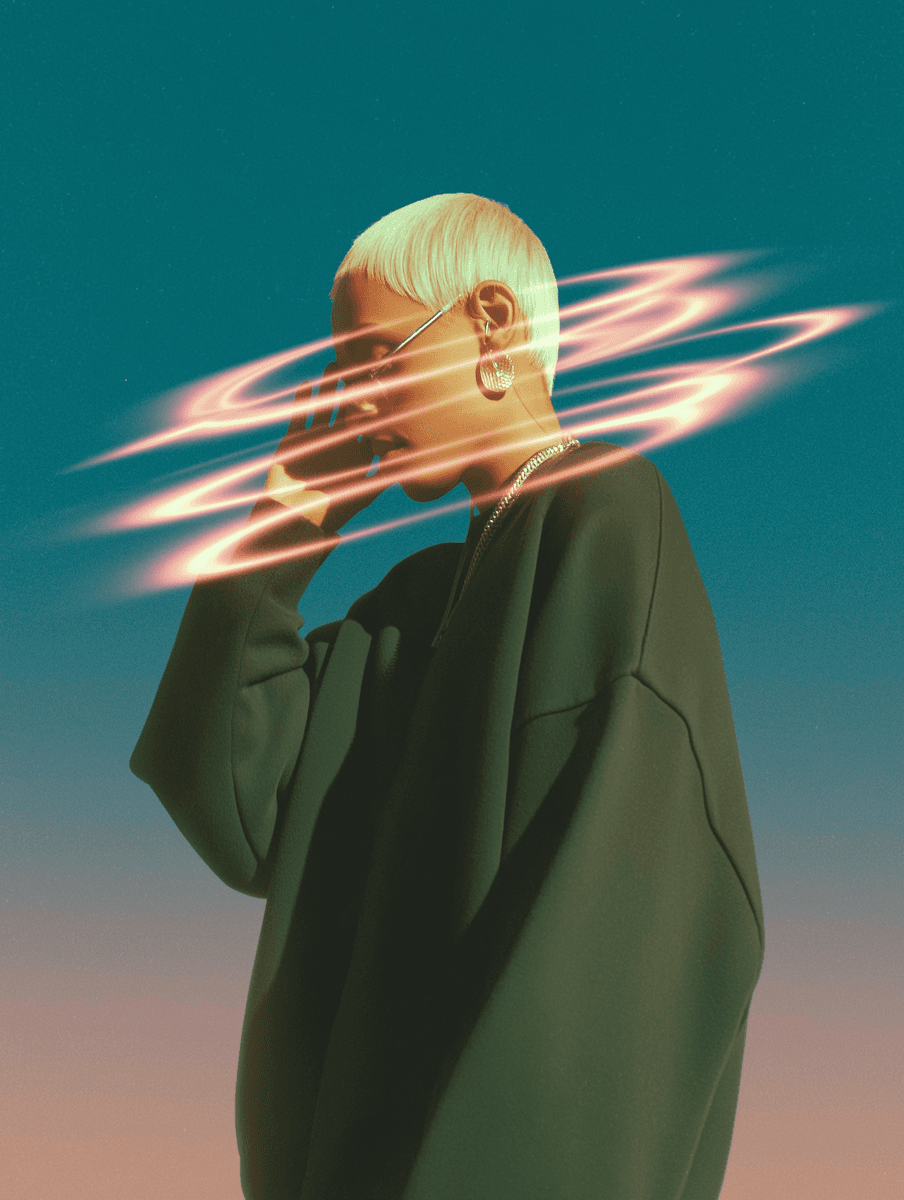 A person with short white hair, wearing earrings and an oversized dark sweater, is captured against a gradient sky background, with swirling neon rings encircling their head, creating a futuristic and artistic effect.