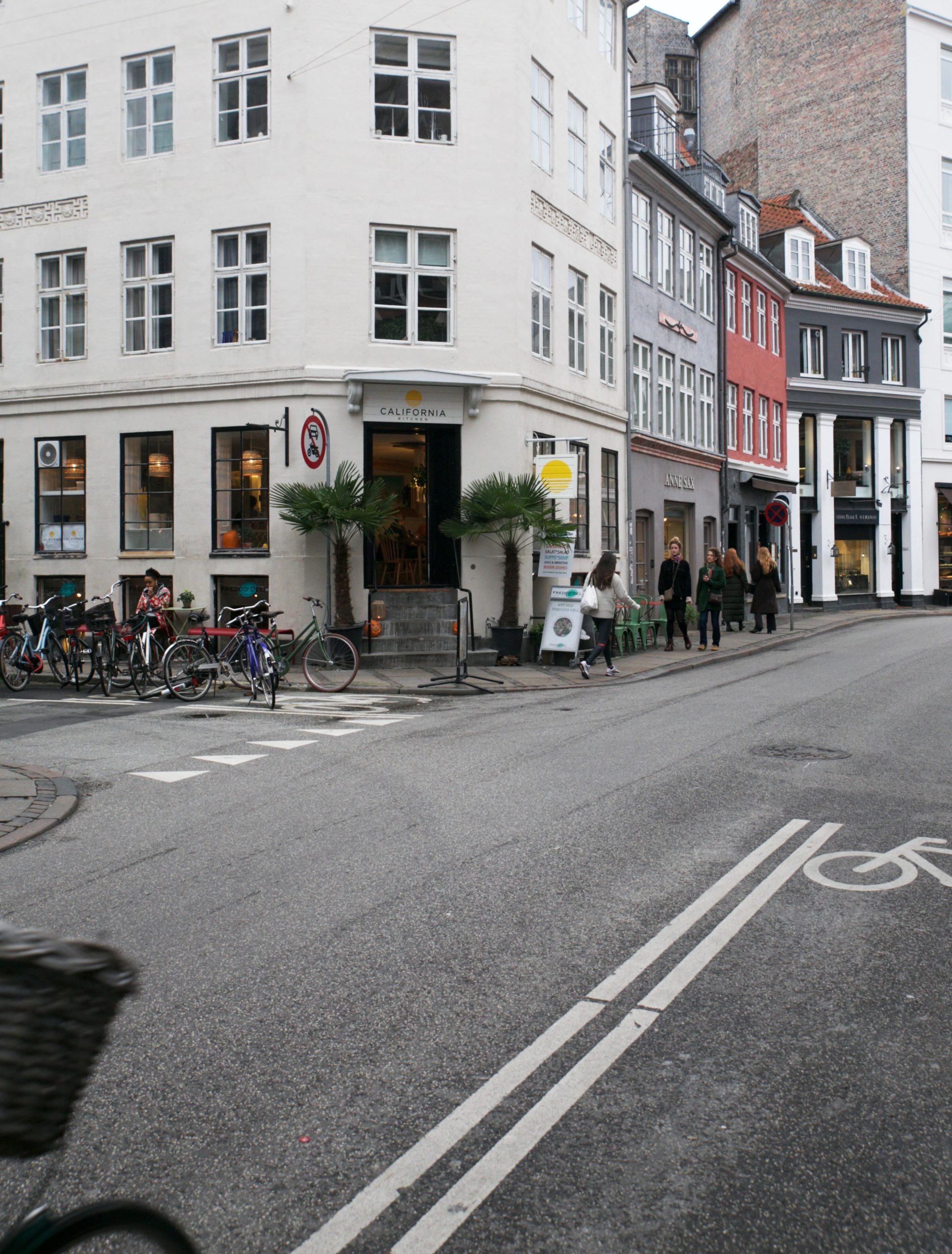 Corner cafe "California Kitchen" with palm trees and bicycles parked outside on a Copenhagen street