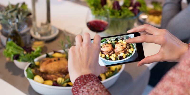 A Malaysian woman taking a photo of her food