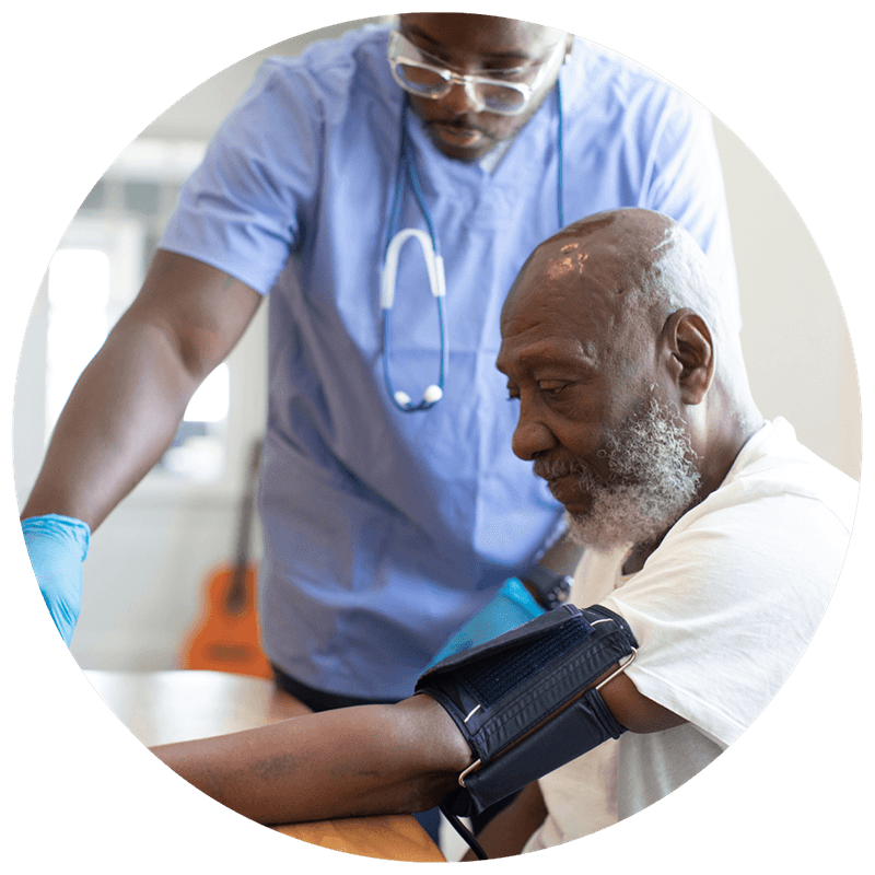 Photo of a patient and nurse with the patient having their blood pressure taken