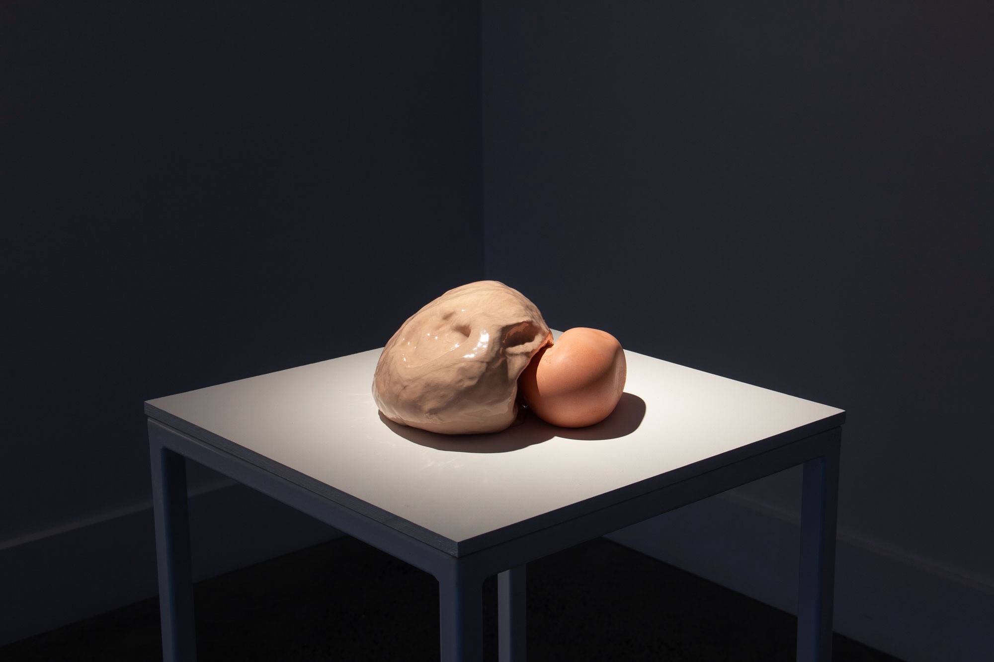 Small ceramic sculpture displayed on a white plinth