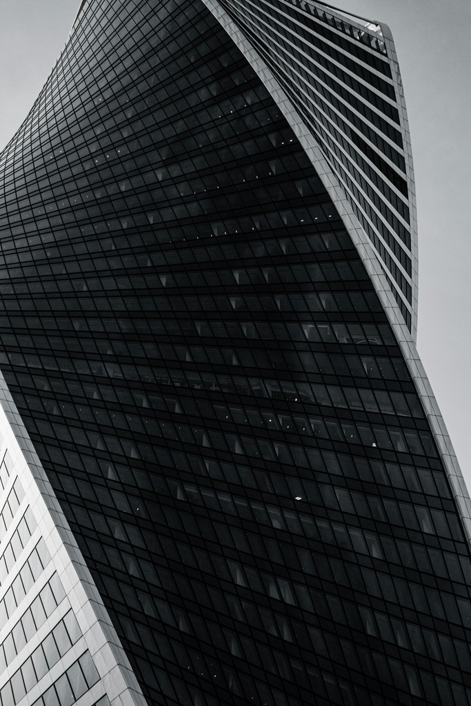 Close-up of a modern building's sleek, dark facade with sharp angles and geometric patterns.