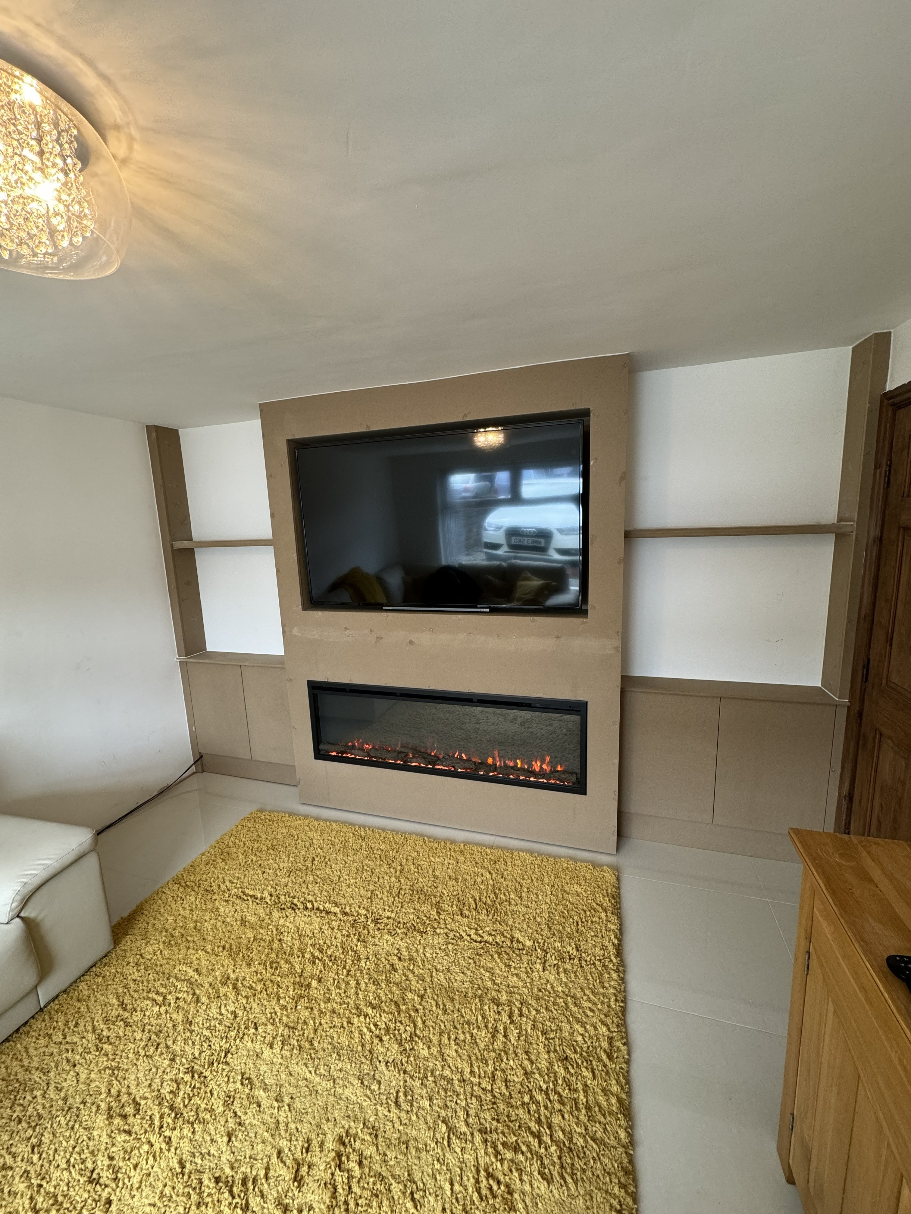 A serene outdoor lounge area with two chairs surrounded by lush greenery and natural light streaming in.