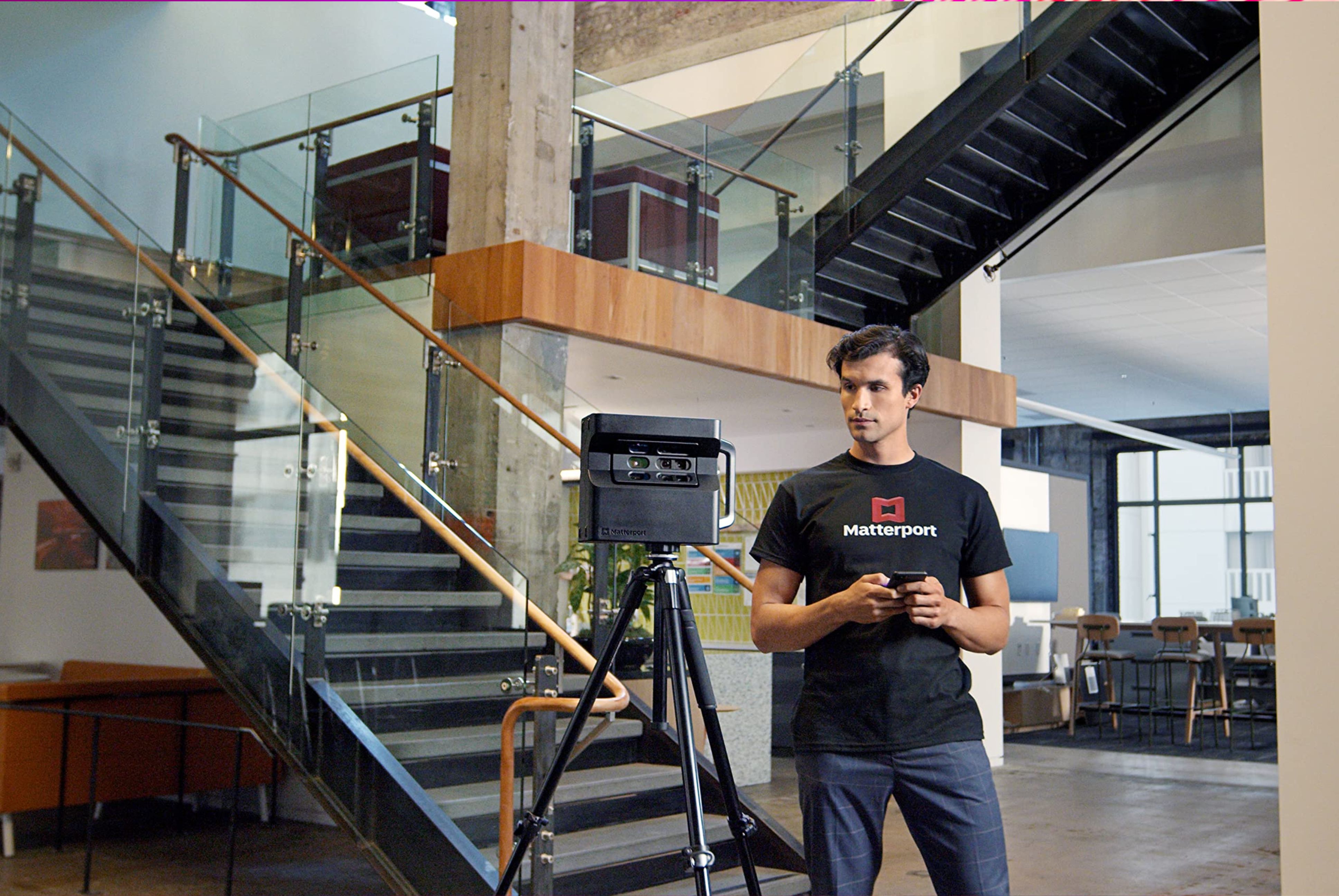 Tecnico al lavoro con una fotocamera 3D su treppiede per realizzare il virtual tour di un immobile