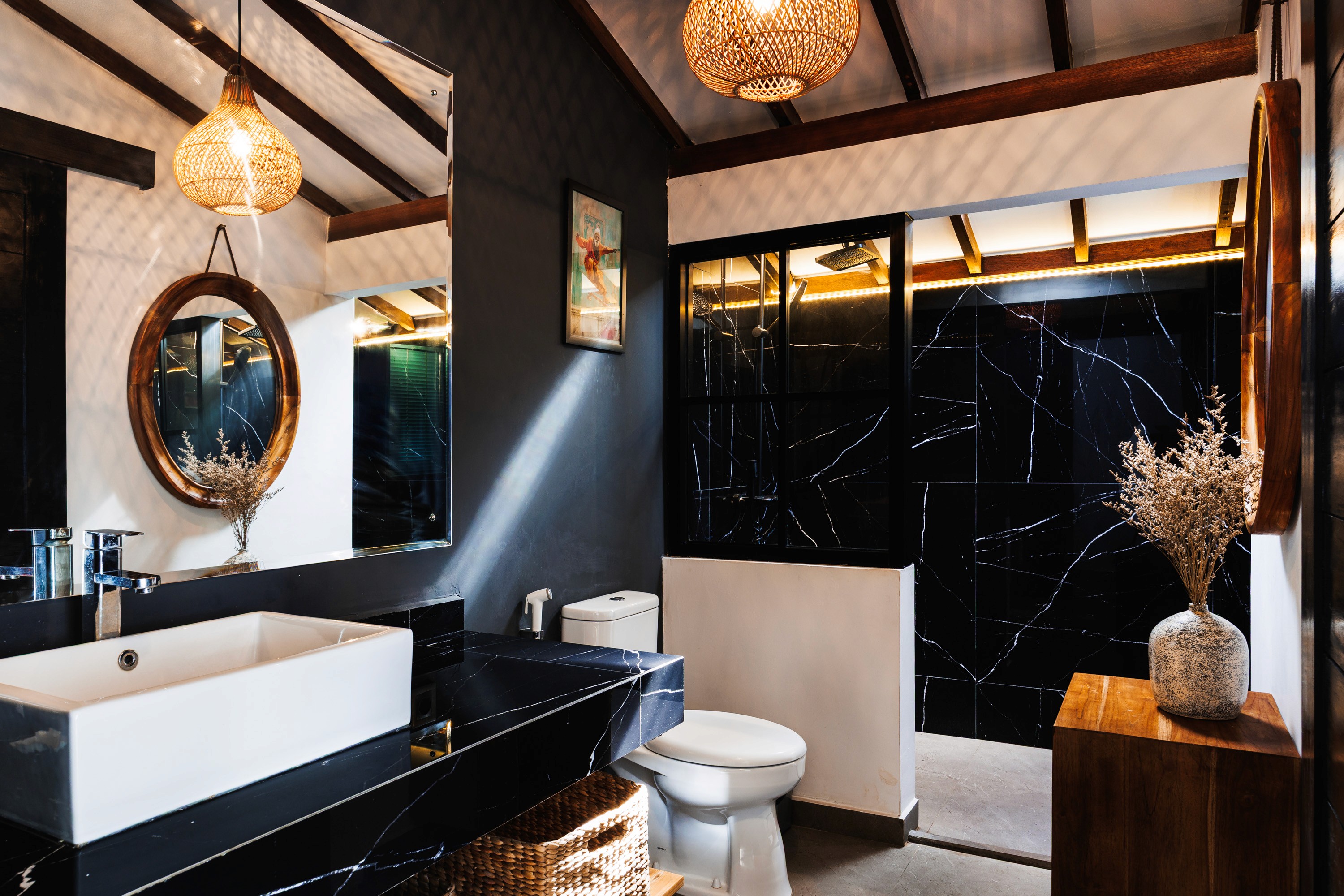 Stylish bathroom with black marble surfaces, wooden accents, and natural lighting