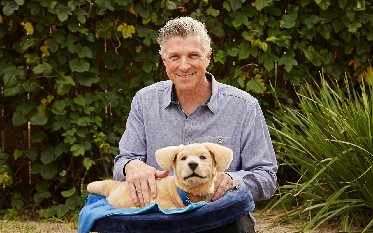 Tombot founder Tom holding robotic therapy dog