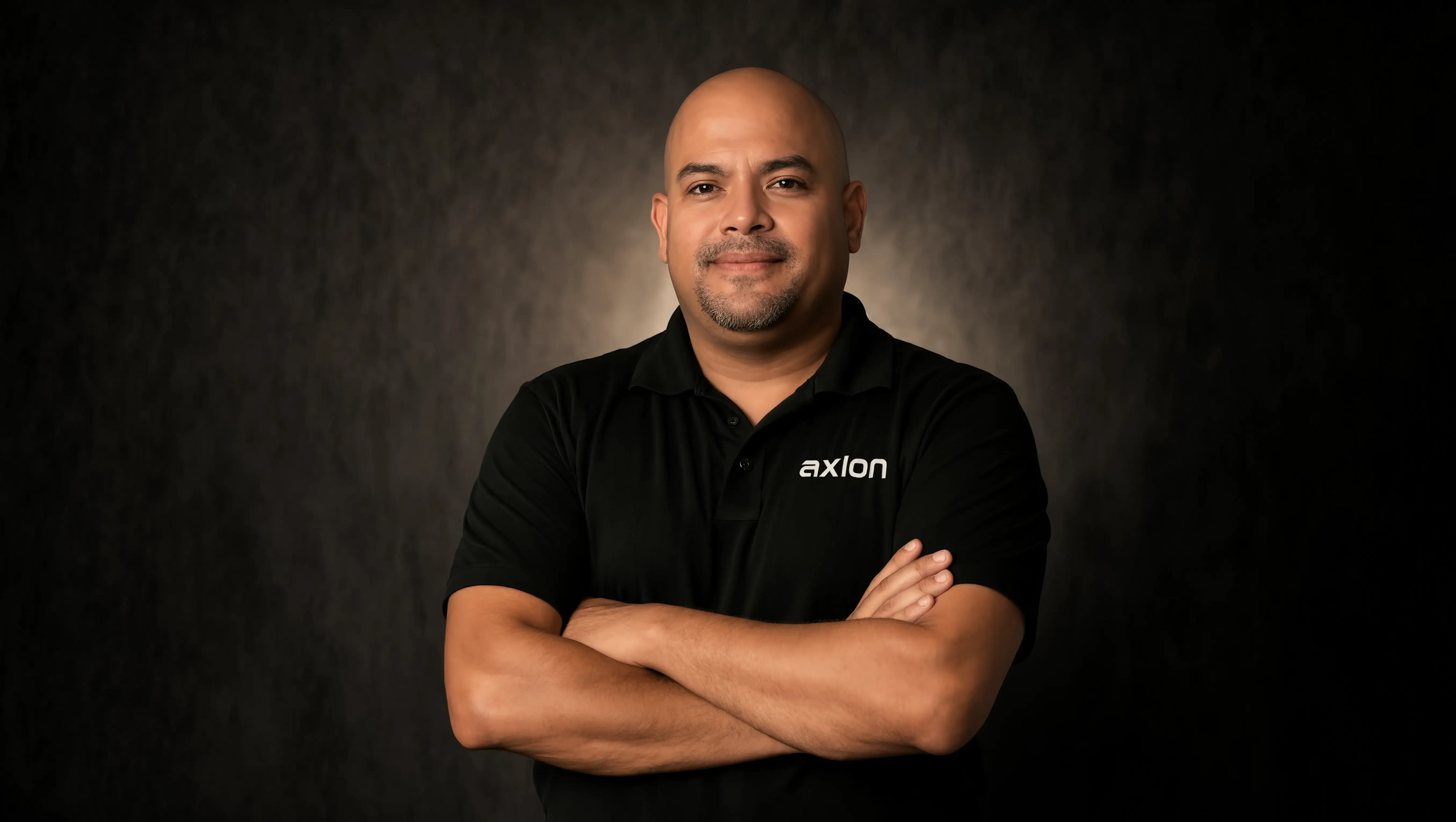 A guy posing with a black polo branded "Axion"