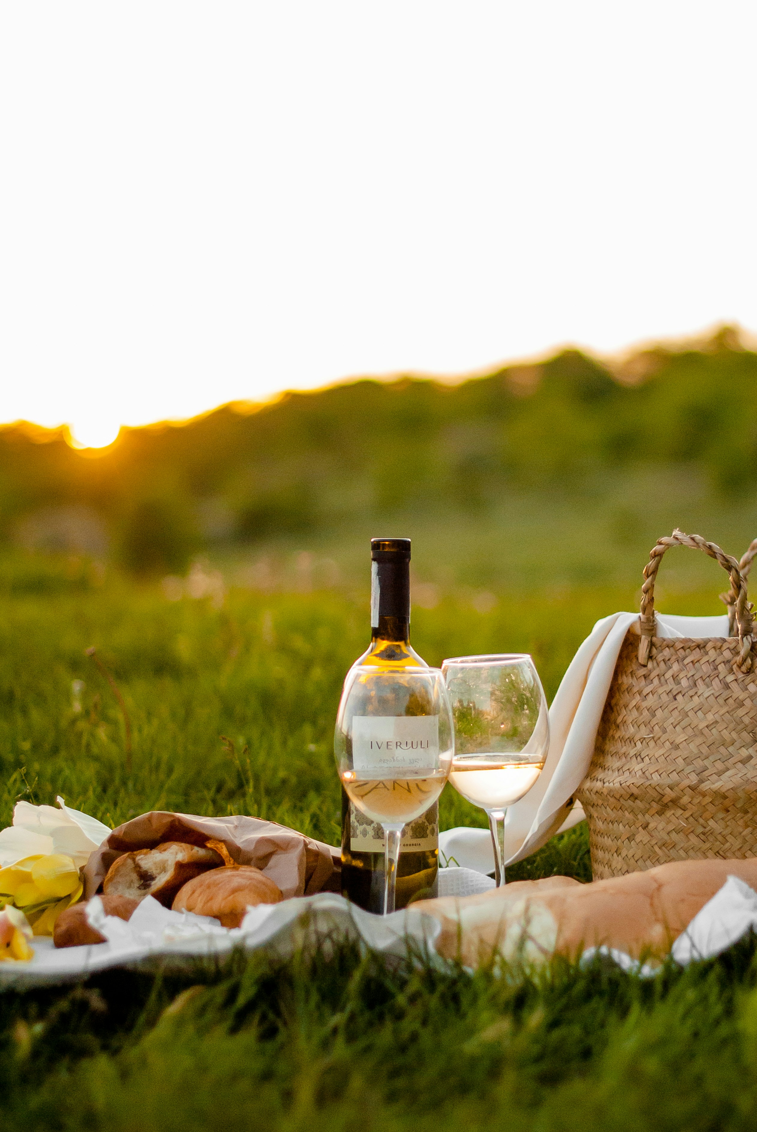 Photo d'un repas extérieur avec une bouteille de vin au milieu d'un paysage naturel