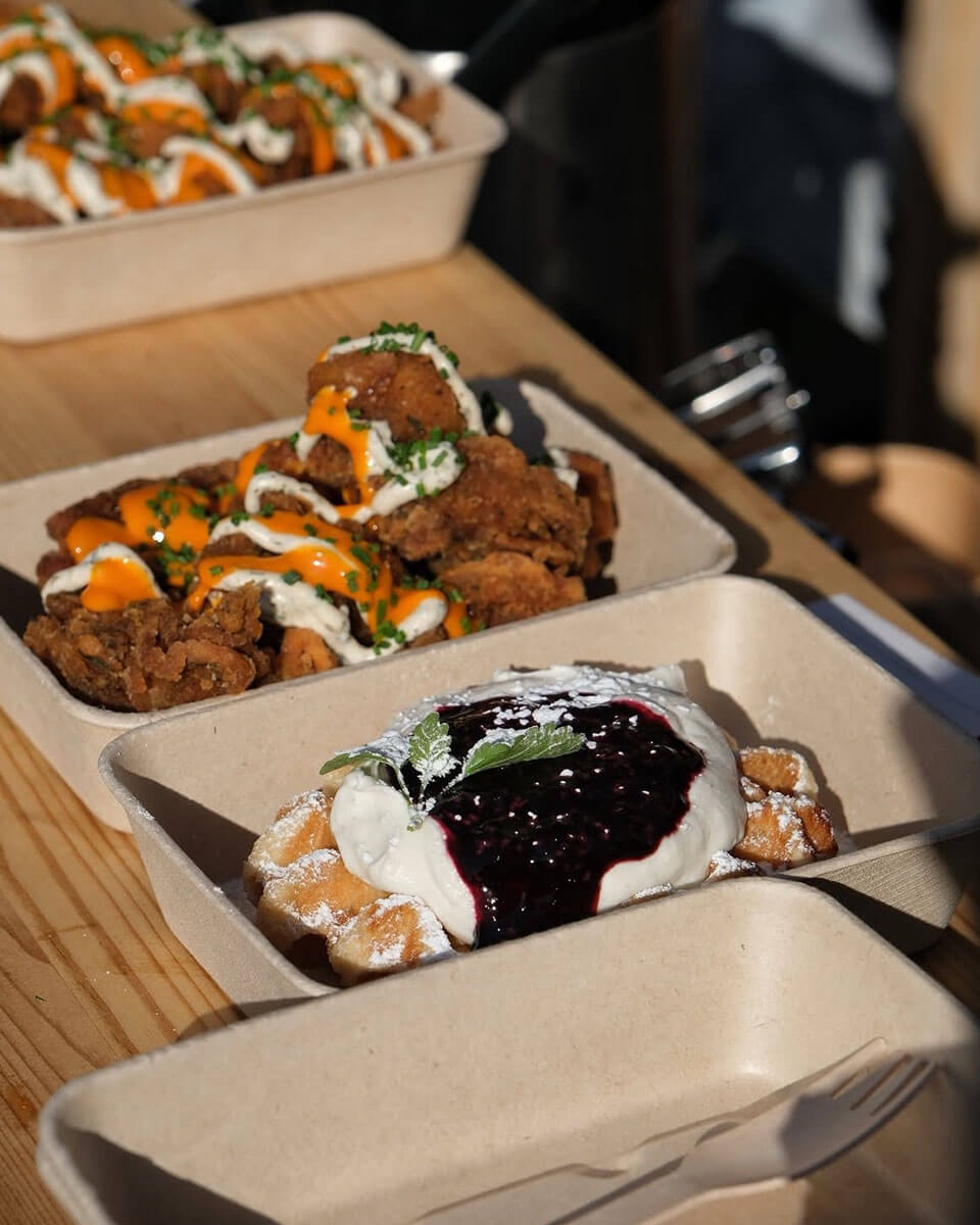 Fried chicken and waffles in takeaway containers placed on the bar