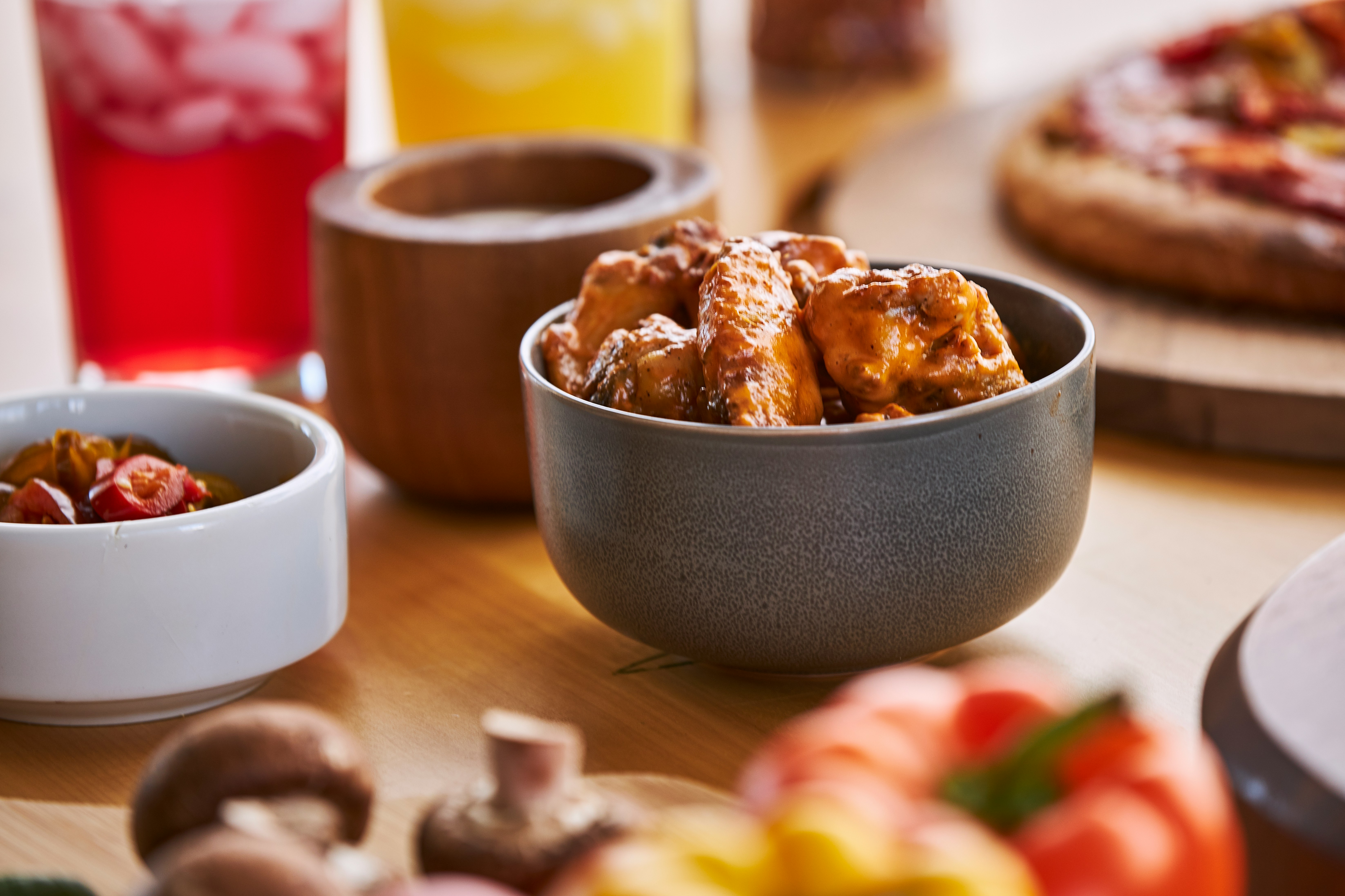 a wooden table topped with bowls of food