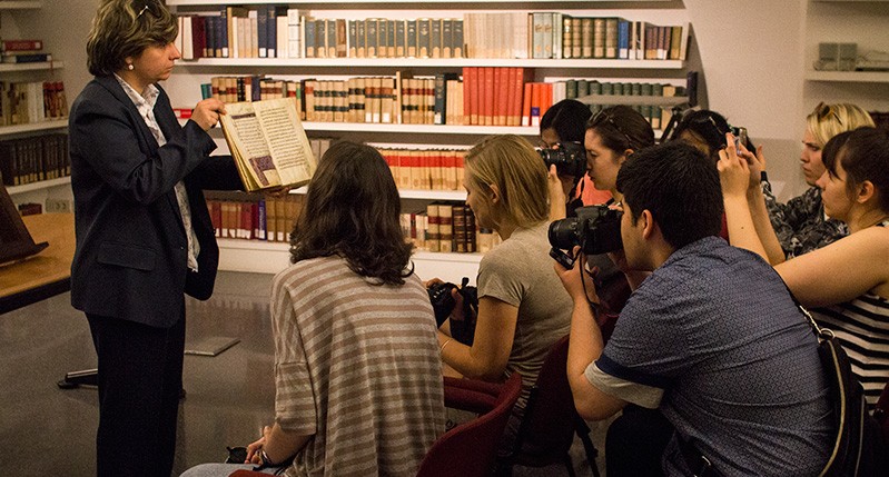 students trying to take pictures of historical book
