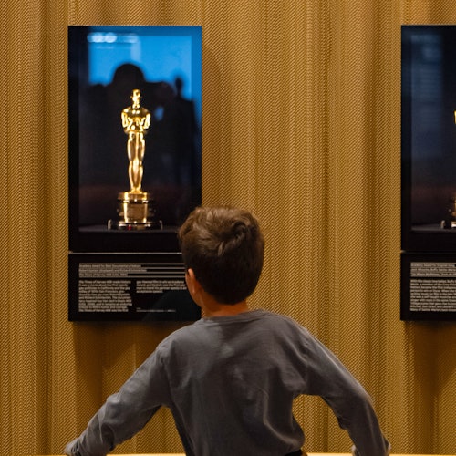 Child observing Oscars statues.