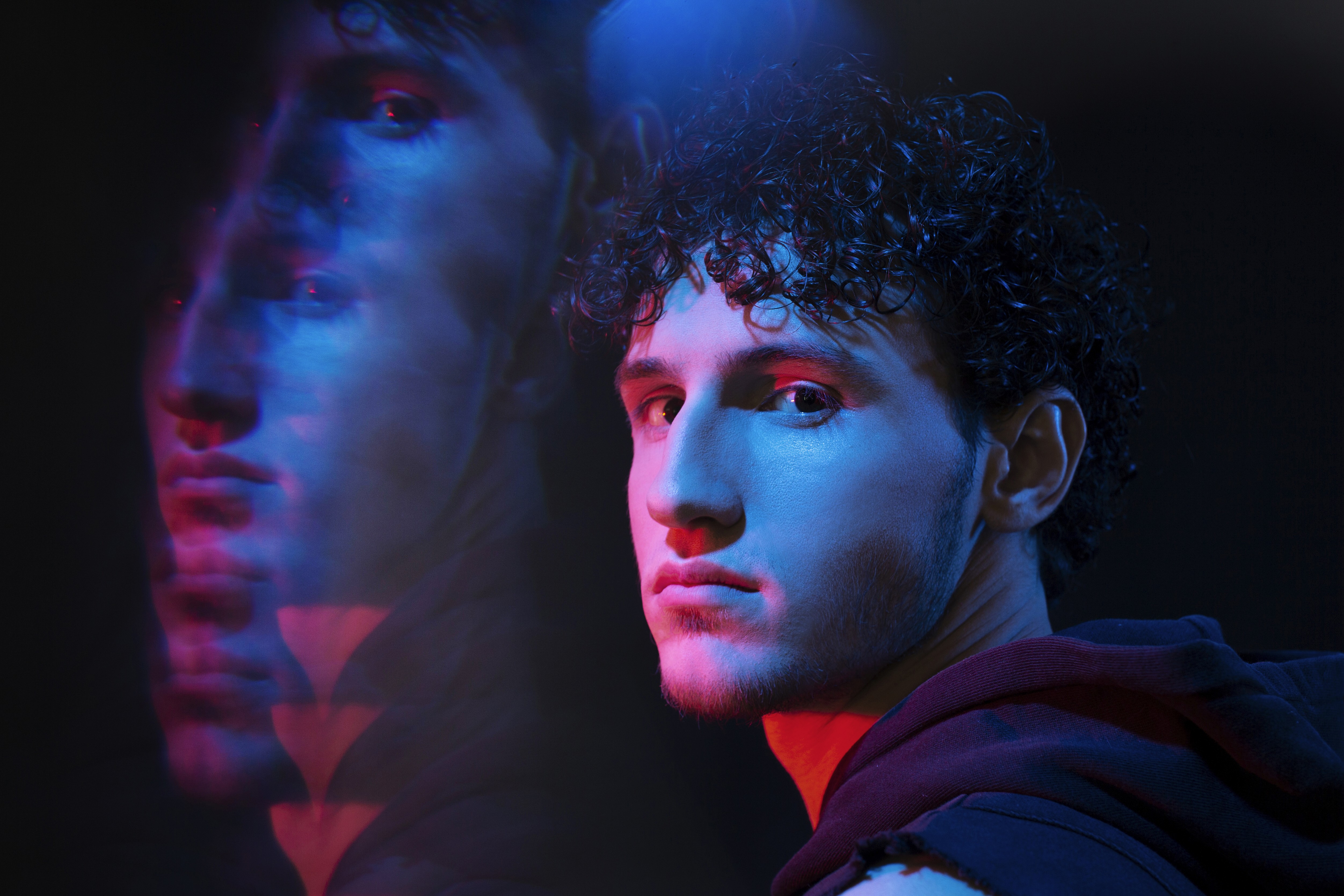 Professional vertical ID card mockup with a purple lanyard and black plastic buckle, featuring a minimalist white and purple brand logo on a solid purple textured background.