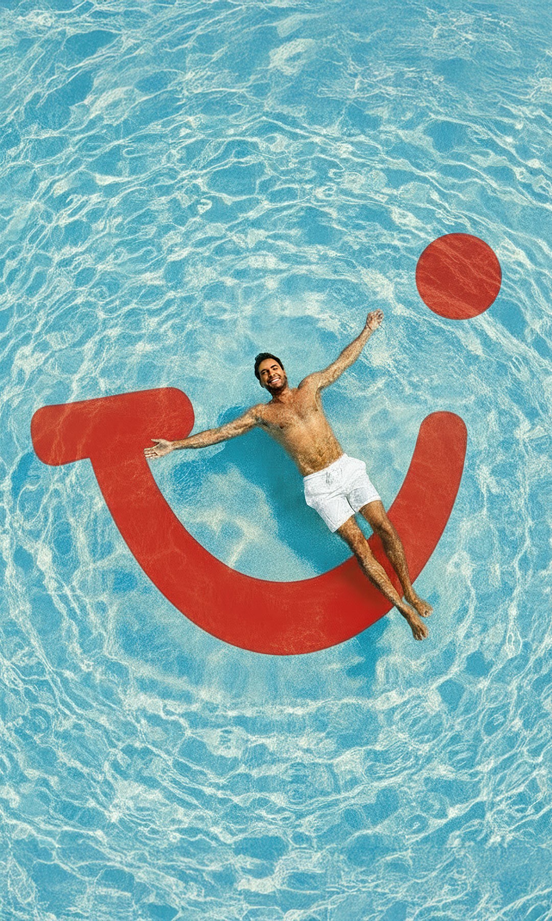 A person is lying relaxed on a red air mattress shaped like the TUI logo in the light blue water.