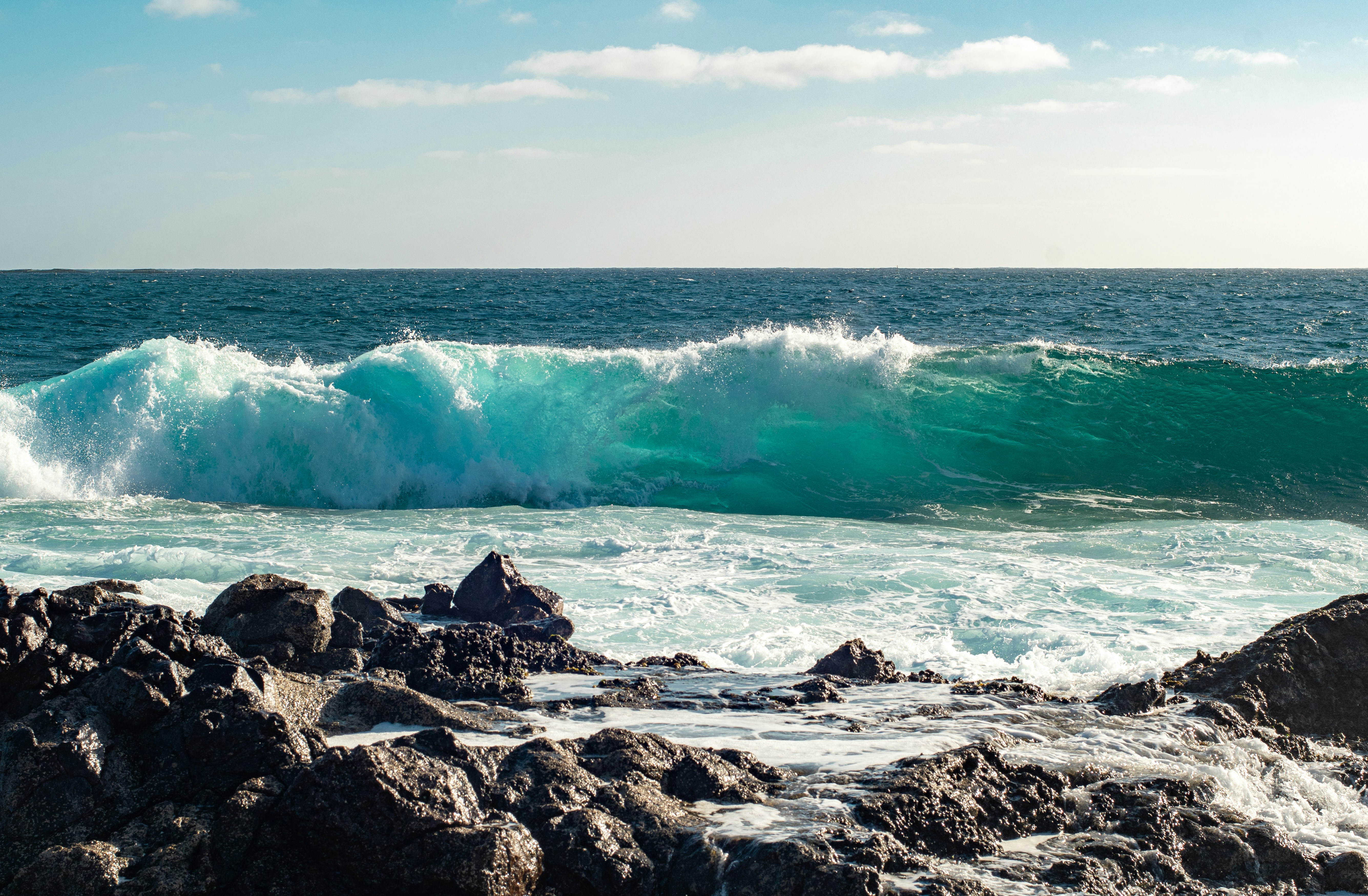 A large body of water sitting next to a rocky shore