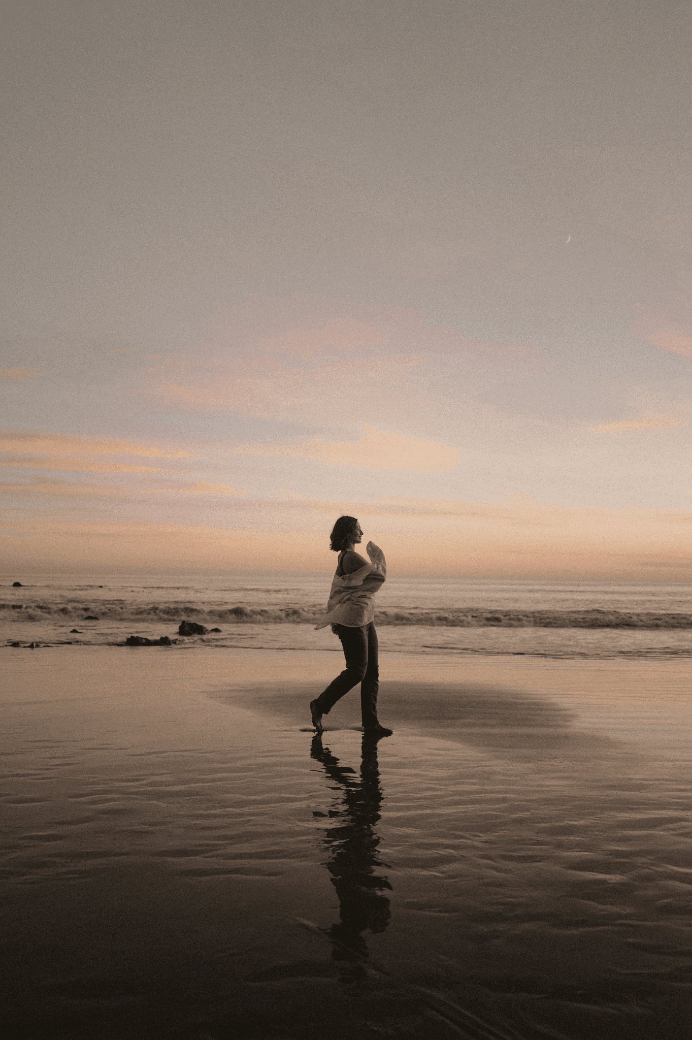 Woman enjoying a beach sunset walk.