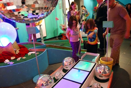 people and kids looking at miscellaneous things displayed in an exhibition