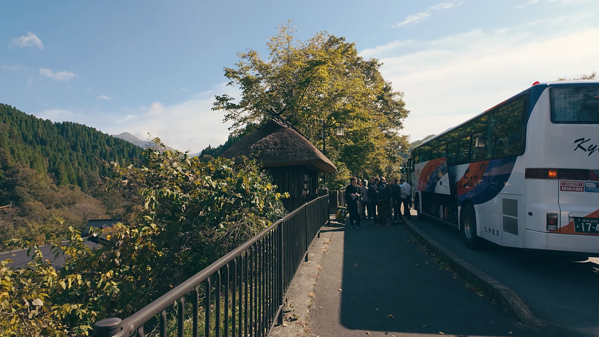 Passengers boarding coaches at the bus stop for Kurokawa Onsen