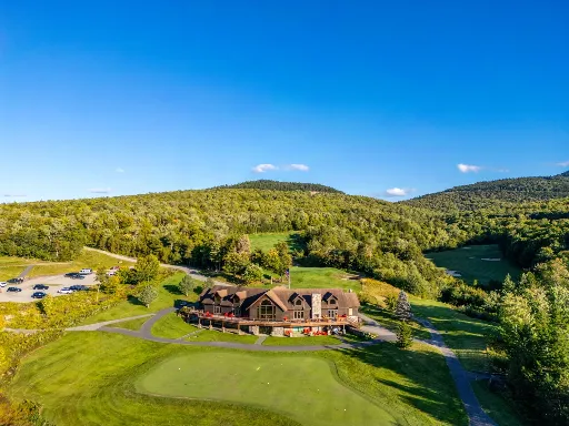 Aerial view of a mountain lodge beside a golf course