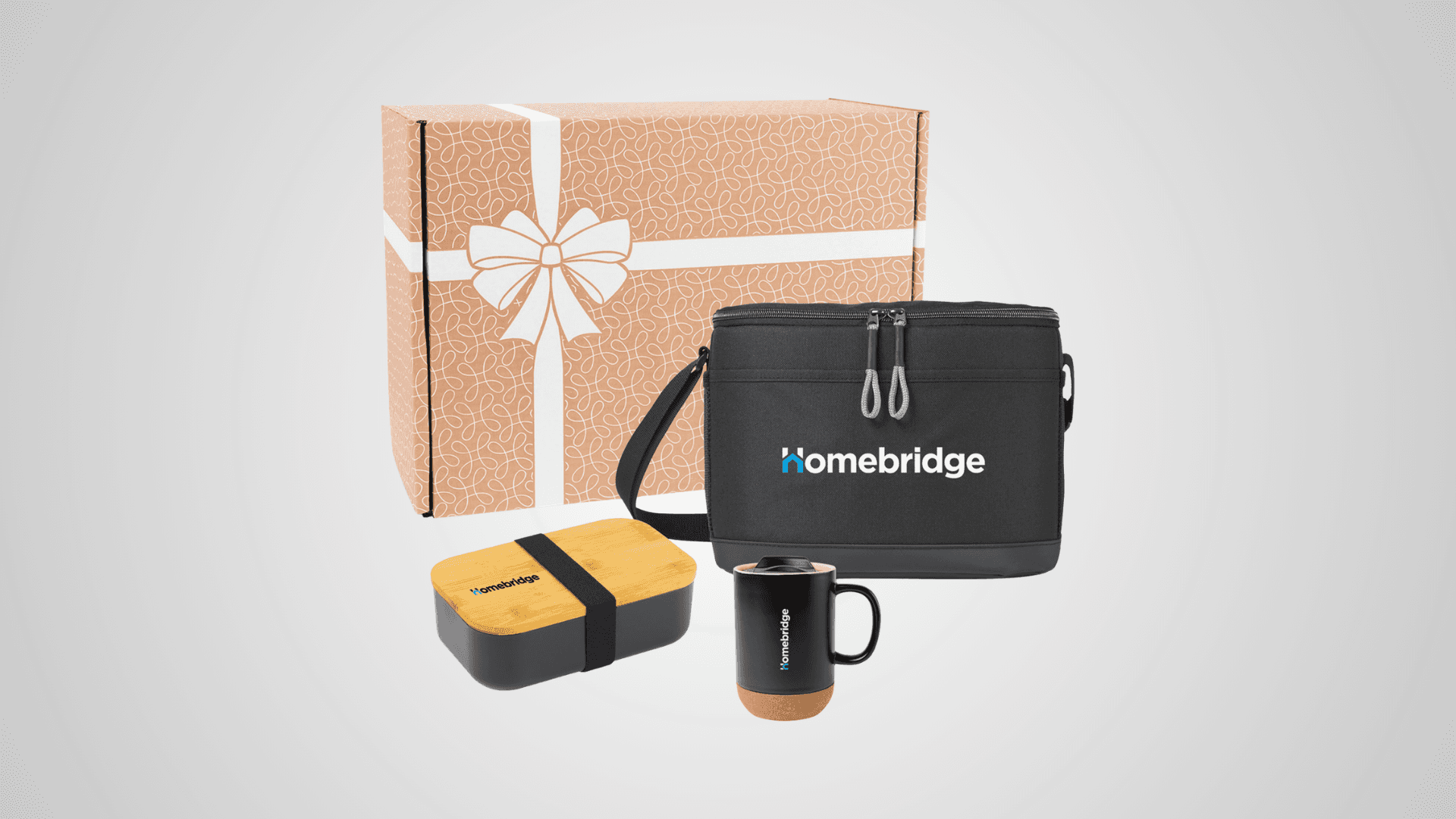 A brown box with the artwork of a bow on a box on it, with a bento box, mug, and luncbox next to each other on a grey background.
