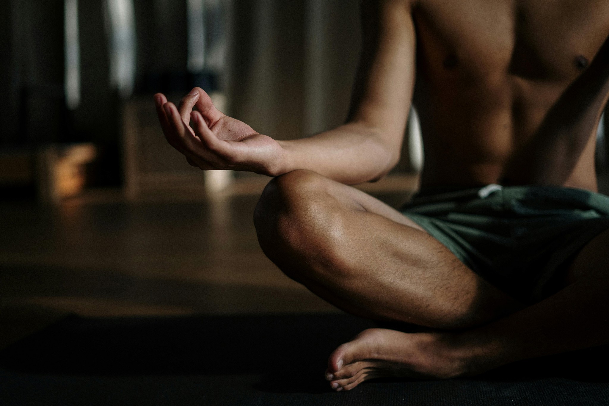 Close-up of a person meditating cross-legged indoors