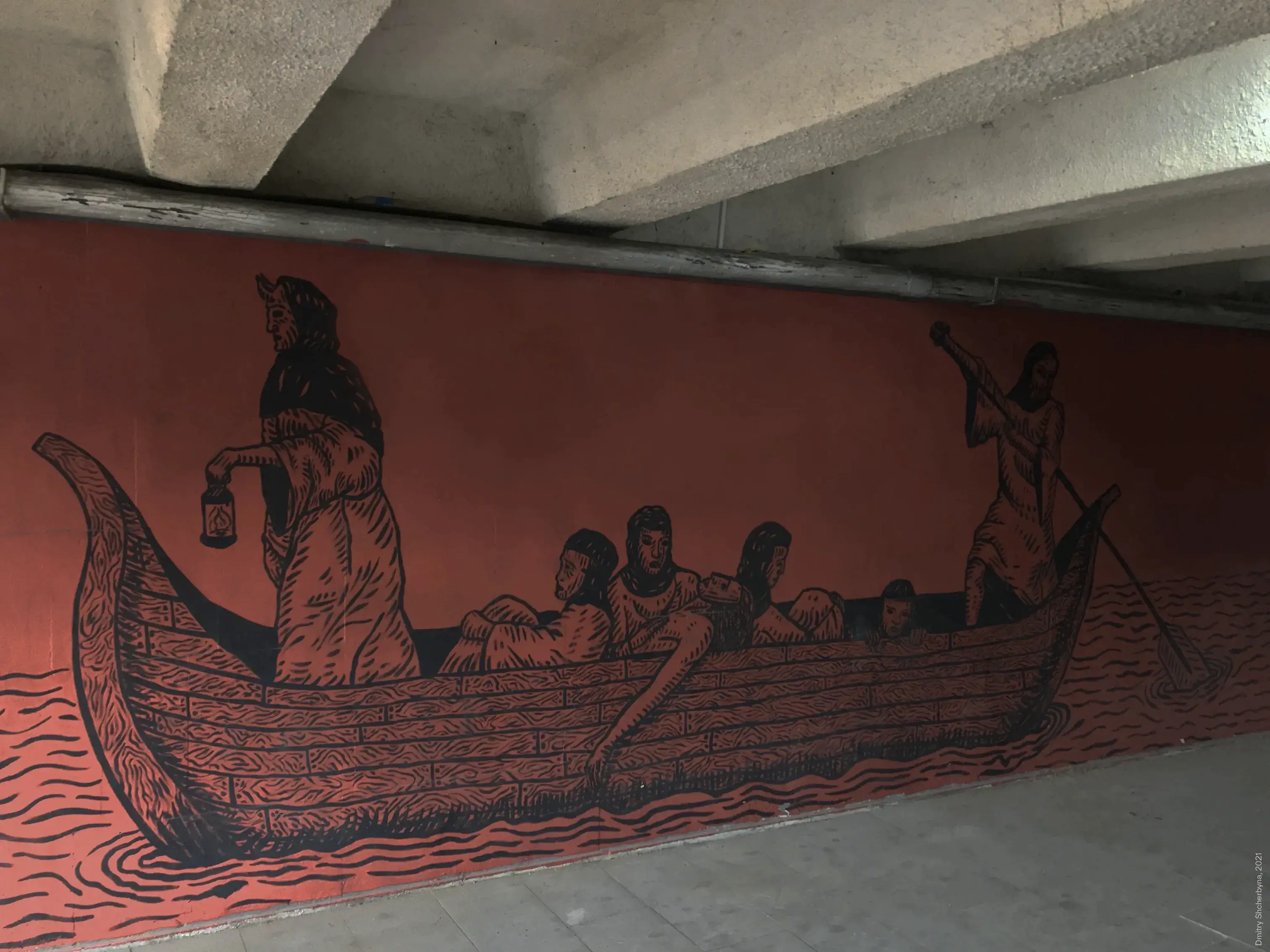 A woodcut-style mural, painted in black on a terracotta background inside an underpass, depicts a long wooden boat carrying several figures across wavy waters. A cloaked figure holds a lantern at the bow and another figure steers the boat with a paddle at the stern.