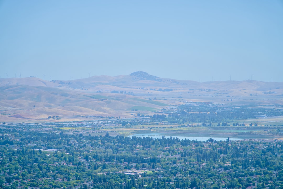 Suburban valley with a reservoir and rolling dry hills stretching to the horizon.