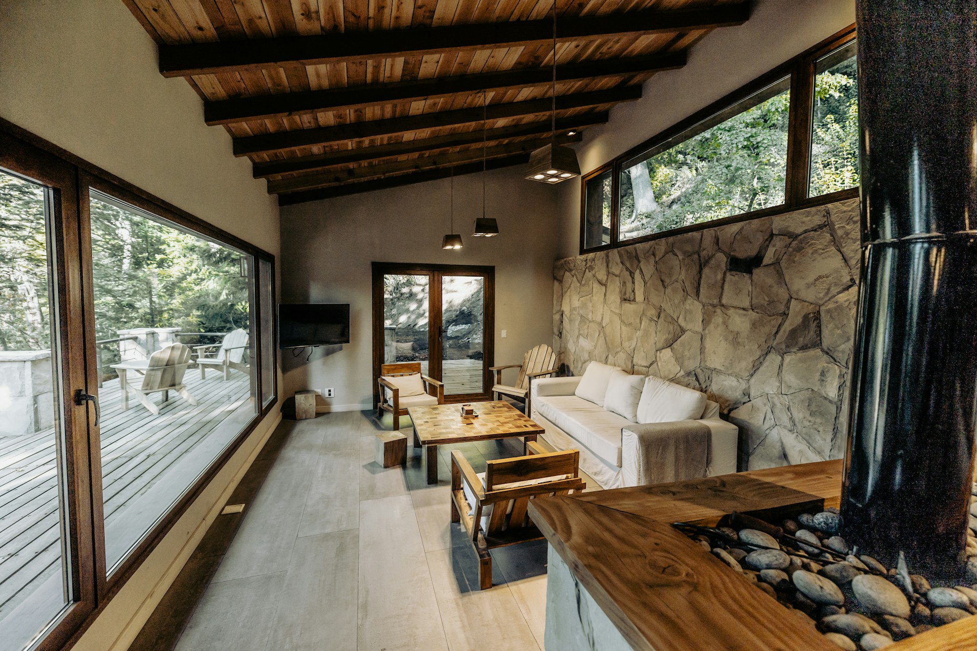 A warm natural retreat space with wood, stone, and forest views