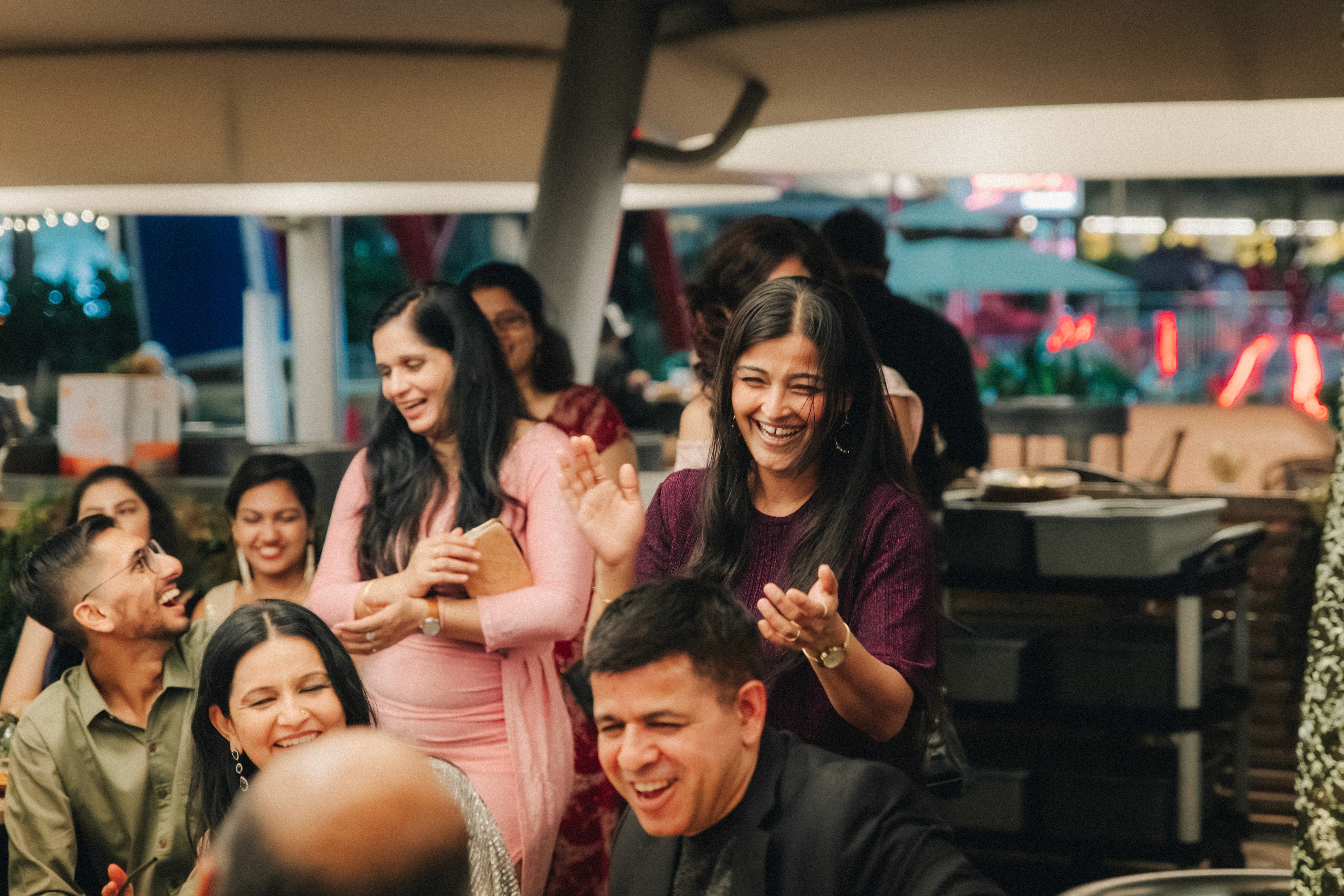 Guests sharing a joyful laugh during the dinner reception at a waterfront restaurant in Clarke Quay.