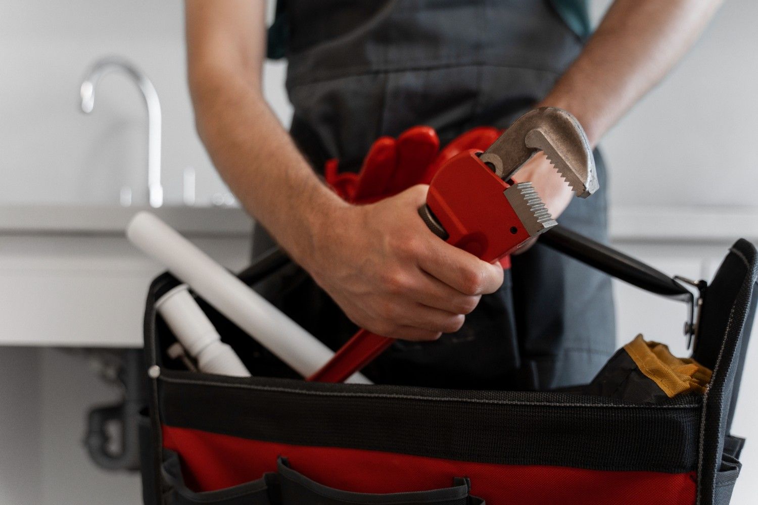 Plumber in Chilliwack, Fraser Valley, British Columbia, holding adjustable wrench and plumbing tools.