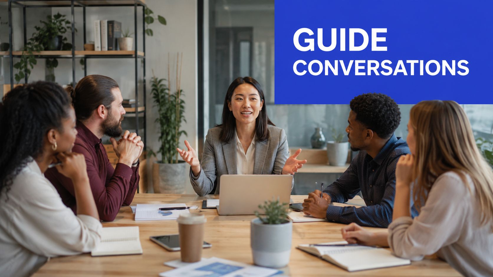 A professional team sitting around a wooden table in an office discussing business strategy during a meeting.