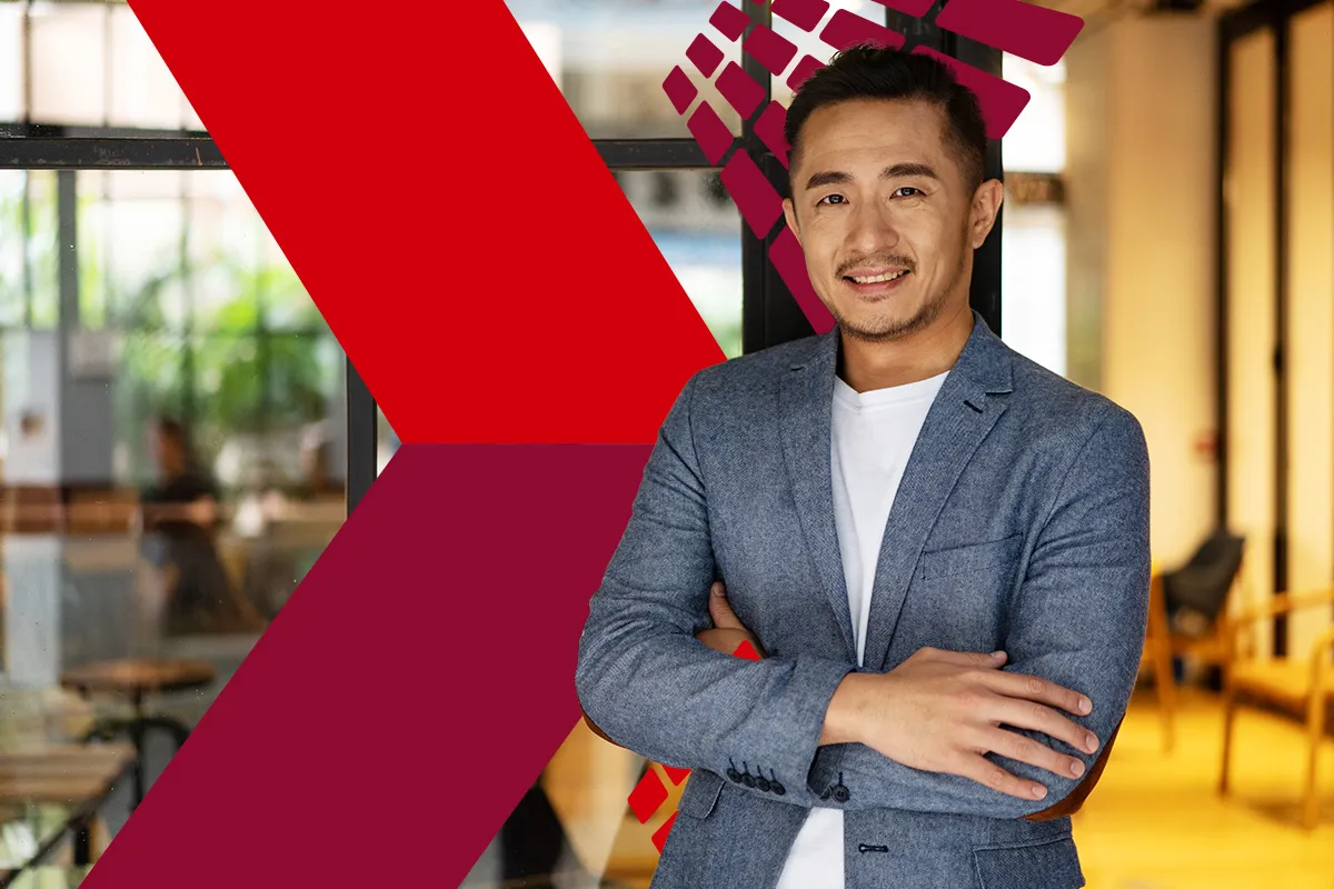 A confident individual wearing a blue blazer and white shirt poses with crossed arms in a modern office setting, featuring a geometric red design on the glass wall, highlighting themes of professionalism and digital innovation in Hong Kong.