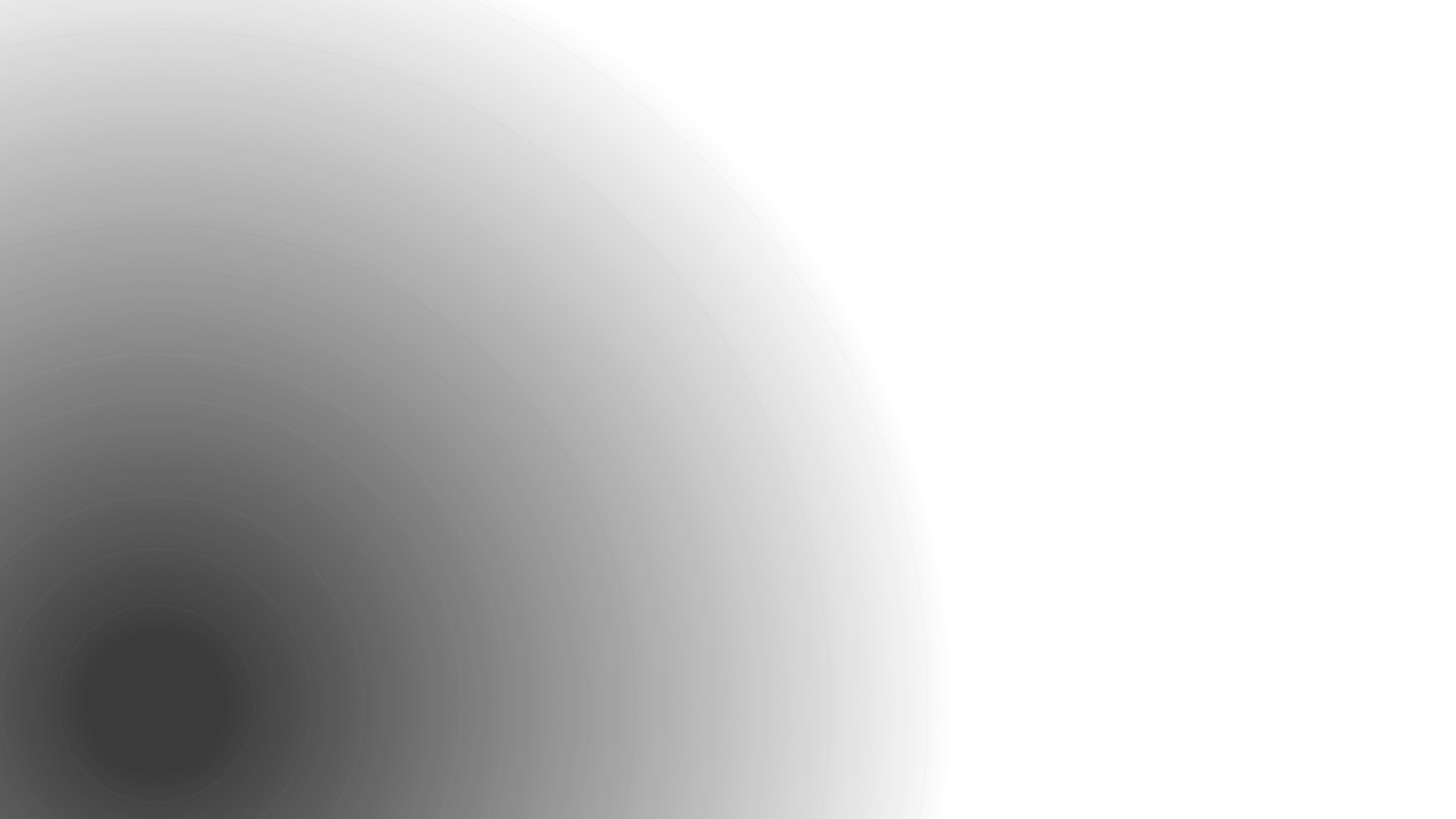 A low-angle shot of a building at dusk with a dark blue sky. The building has long, dark blue glass windows, with a few of them glowing with a warm orange light. The building's architecture is modern with a slightly curved corner.