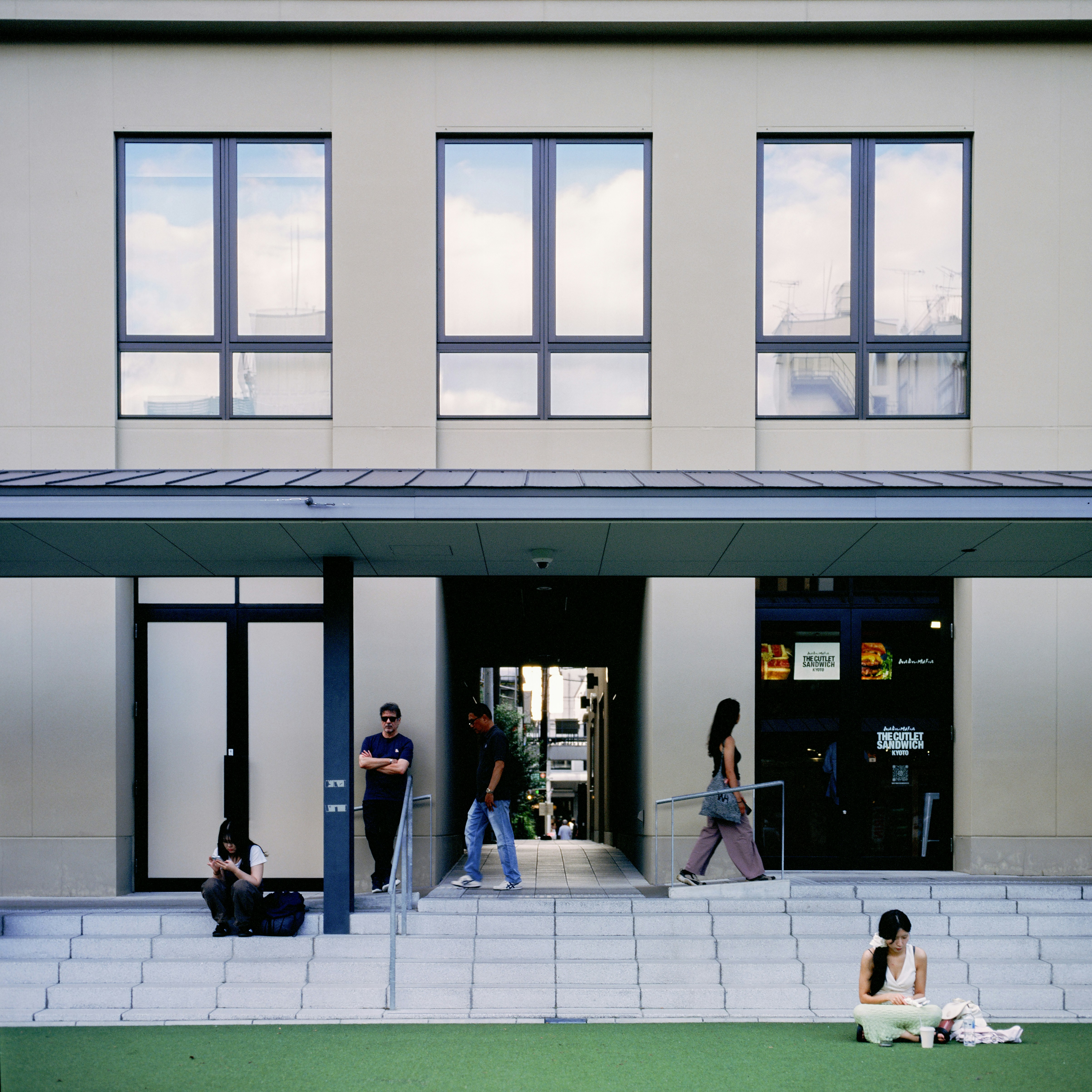 People on steps outside modern building entrance
